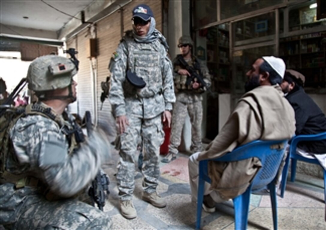 U.S. Army Staff Sgt. Brain Sewick (left), a platoon sergeant with Tactical Psychological Operations Team 1316, asks a series of questions to Afghans during a patrol in Khost City, Khost province, Afghanistan, on Dec. 5, 2010.  The purpose of the patrol was to assess local insurgent activity during daytime hours.  