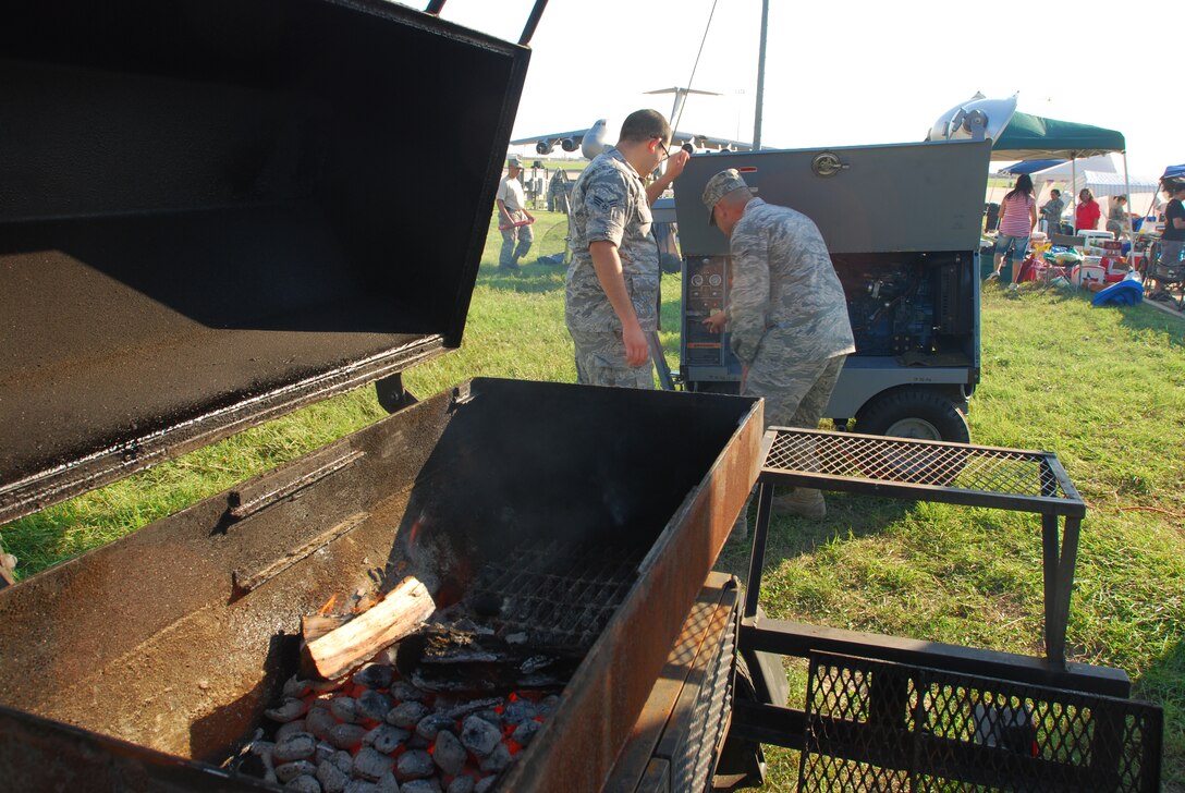 Members of the 433rd Airlift Wing gathered on the Saturday of a combined unit training assembly to celebrate the support of their families during the 2010 Family Day. The event was open to family members of Alamo Wing reservists, and featured games, carnival style food and motorcycle and car shows. Charcoal burns down to a hot smolder  while Airman 1st Class Tony Reyes and Senior Airman Joshua Olivares start a generator. (U.S. Air Force photo/Airman 1st Class Brian McGloin)