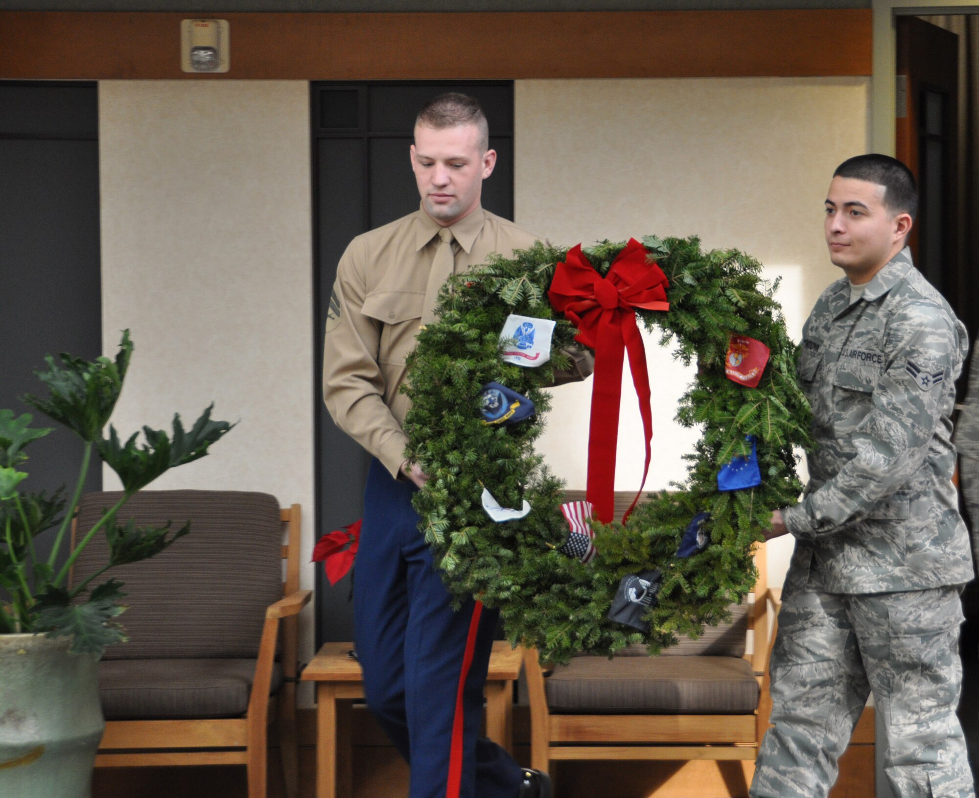 Marine Cpl. Matthew Duerr and Air Force Airman 1st Class Vincent Montoya carry a wreath Dec. 11, 2010 at Air Force Mortuary Affairs Operations as part of a Wreath Across America Ceremony to honor those who have made the ultimate sacrifice. (U.S. Air Force photo/Christin Michaud)  