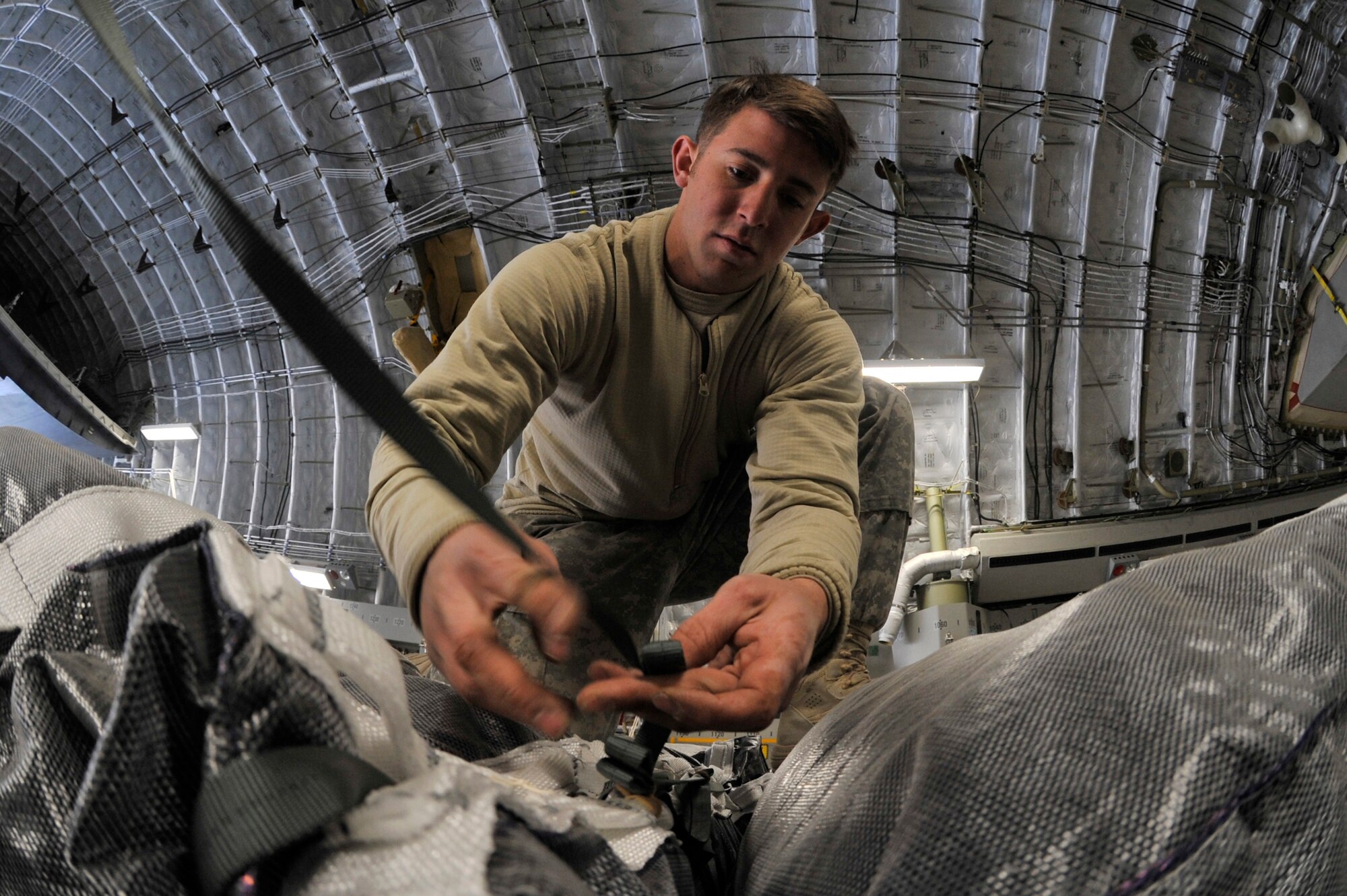 SPC. David Casper, a parachute rigger assigned to the 82nd Sustainment Brigade, stows excess static line for a bundle of fuel on C-17 Globemaster III at Bagram Airfield, Afghanistan, Dec. 10, 2010. The Globemaster fleet has surpassed 2 million flying hours since production began in 1993.  The airframe accumulated 1 million flying hours between 1993 and 2006. Specialist Casper is a native of Chesapeake, Virginia. (U.S. Air Force photo/Staff Sgt. Christopher Boitz)
