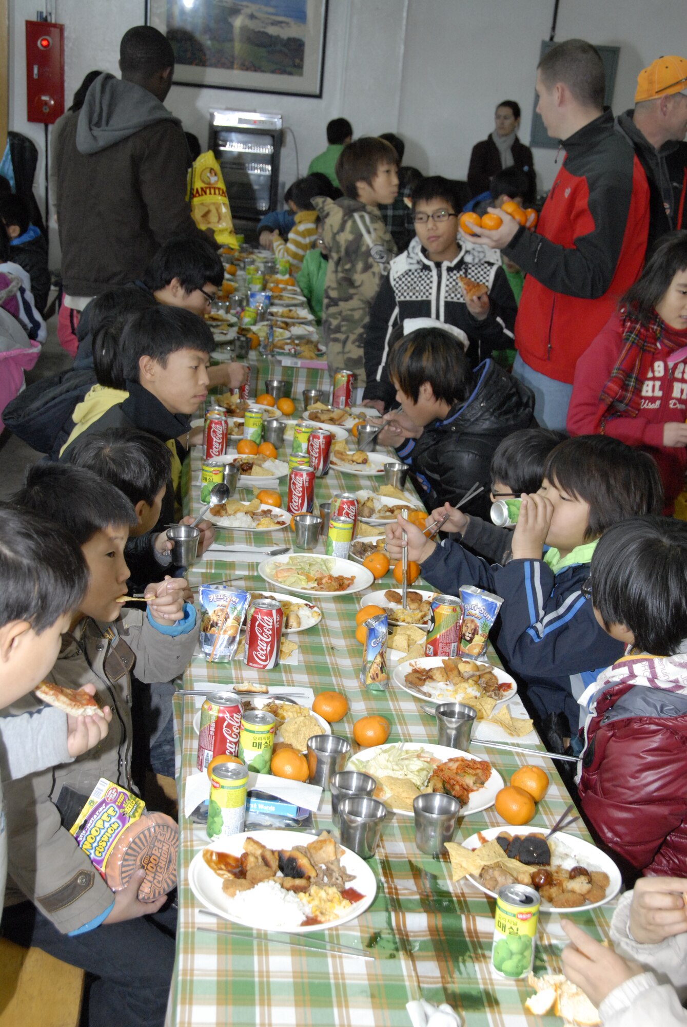 KUNSAN AIR BASE, Republic of Korea -- Children from the the Il Mag Won orphanage eat lunch that was provided and served by the Wolf Pack Dec. 11.  Volunteers from the base chapel coordinated a holiday party for the children at the orphanage, where volunteers donated time, gifts, food and more to the children to celebrate the holiday season.  (U.S. Air Force photo/Capt. Sheryll Klinkel)
