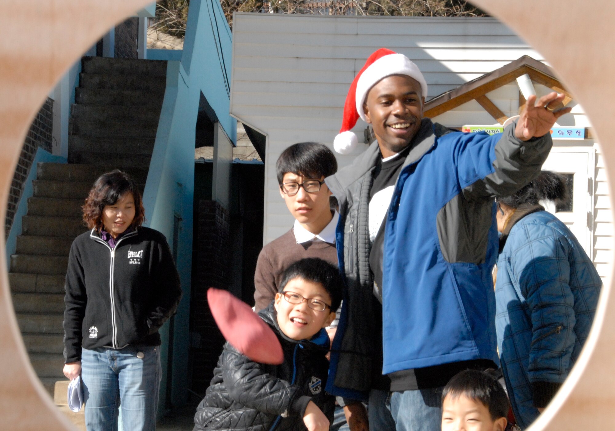 KUNSAN AIR BASE, Republic of Korea -- Senior Airman Lawrence O'neal, 8th Medical Operations Squadron, facilitates a bean bag throwing contest at the the Il Mag Won orphanage Dec. 11.  Airman O'neal and other Wolf Pack members from the base chapel coordinated a holiday party for the children at the orphanage, where volunteers donated time, gifts, food and more to the children.  (U.S. Air Force photo/Capt. Sheryll Klinkel)