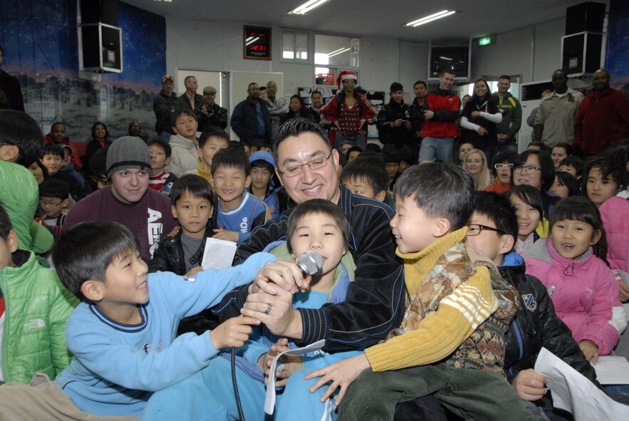KUNSAN AIR BASE, Republic of Korea -- Master Sgt. John DeSpain, 8th Medical Operations Squadron, sings Christmas carols with children from the Il Mag Won orphanage Dec. 11.  Sergeant DeSpain and other Wolf Pack members from the base chapel coordinated a holiday party for the children at the orphanage, where volunteers donated time, gifts, food and more to the children.  (U.S. Air Force photo/Capt. Sheryll Klinkel)