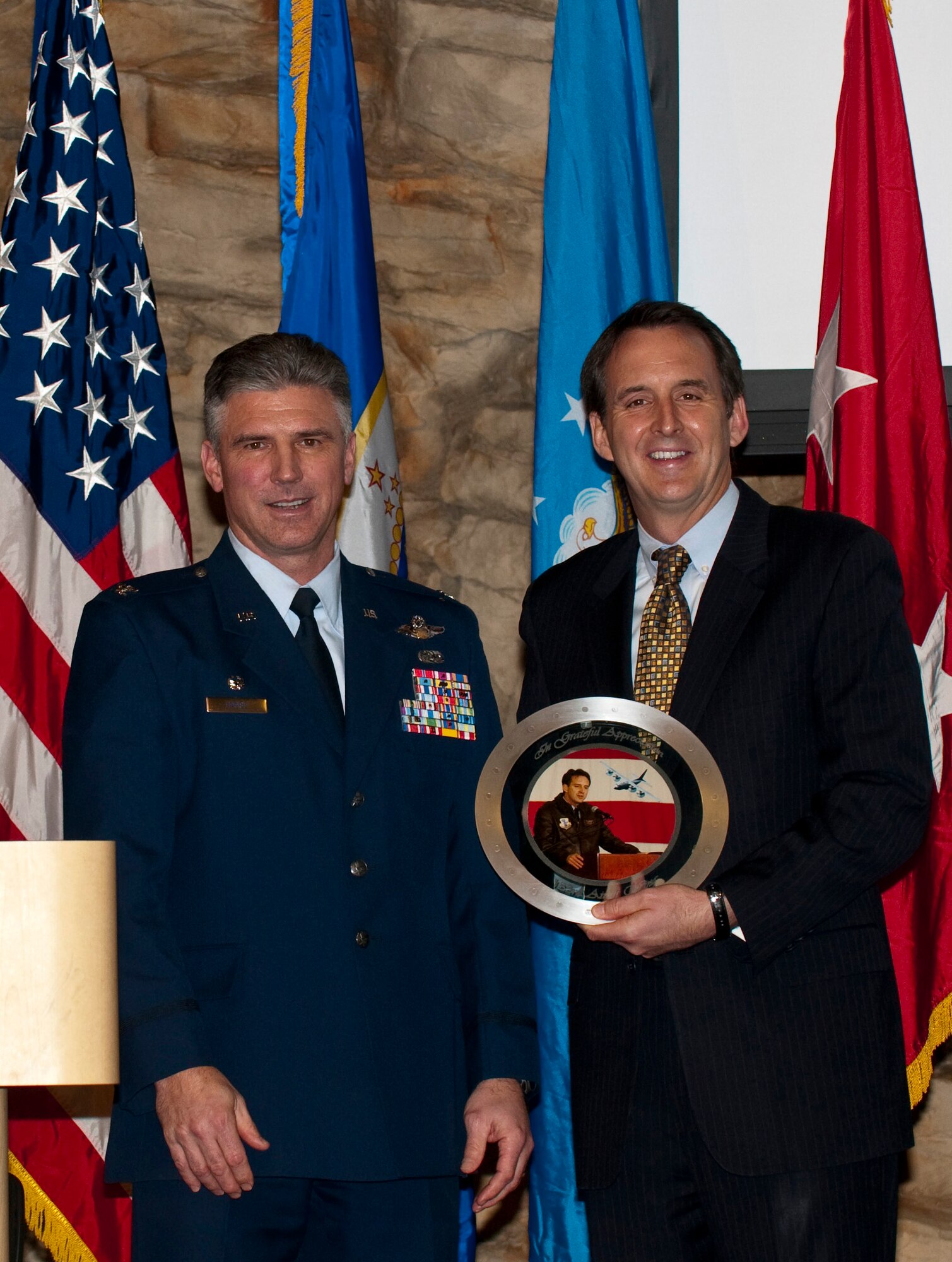 Governor of Minnesota Tim Pawlenty receives a gift from 133rd Airlift Wing commander Col. Greg Haase during the 133rd Airlift Wing Recognition Ceremony Dec. 11, 2010 in St. Paul, Minn. USAF photo by Tech. Sgt. Erik Gudmundson