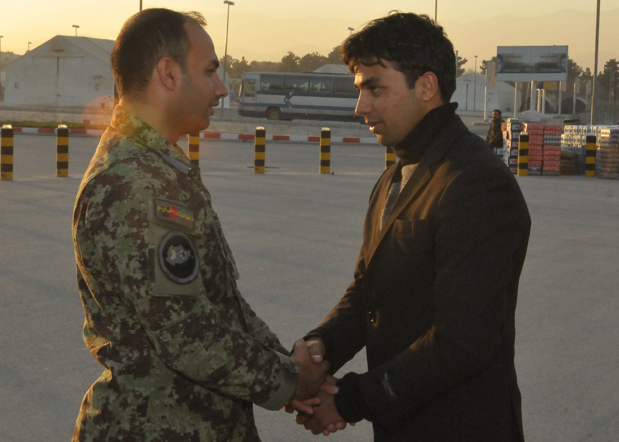 101211-N-6541W-031 KABUL, Afghanistan - A Member of the Afghan Air Force who is leaving to go to a partner nation in the middle east for pilot and English training says good bye to a fellow student at Kabul International Airport Dec. 11th.  (U.S. Navy photo by Mass Communication Specialist 3rd Class Jared Walker/ RELEASED).