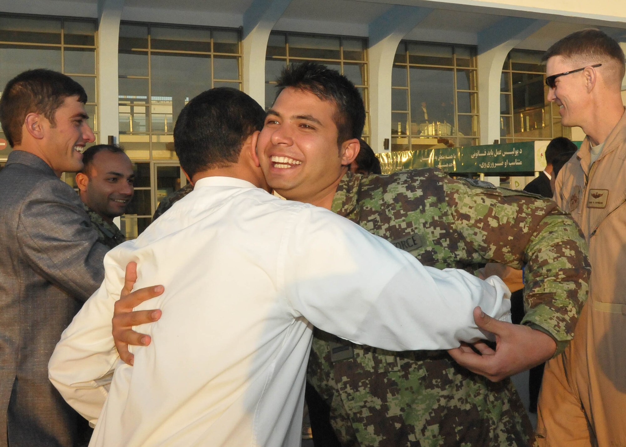 101211-N-6541W-031 KABUL, Afghanistan - Member of the Afghan Air Force who is leaving to go to a partner nation in the middle east for pilot and English training hugs a fellow student at Kabul International Airport Dec. 11th.  (U.S. Navy photo by Mass Communication Specialist 3rd Class Jared Walker/ RELEASED).