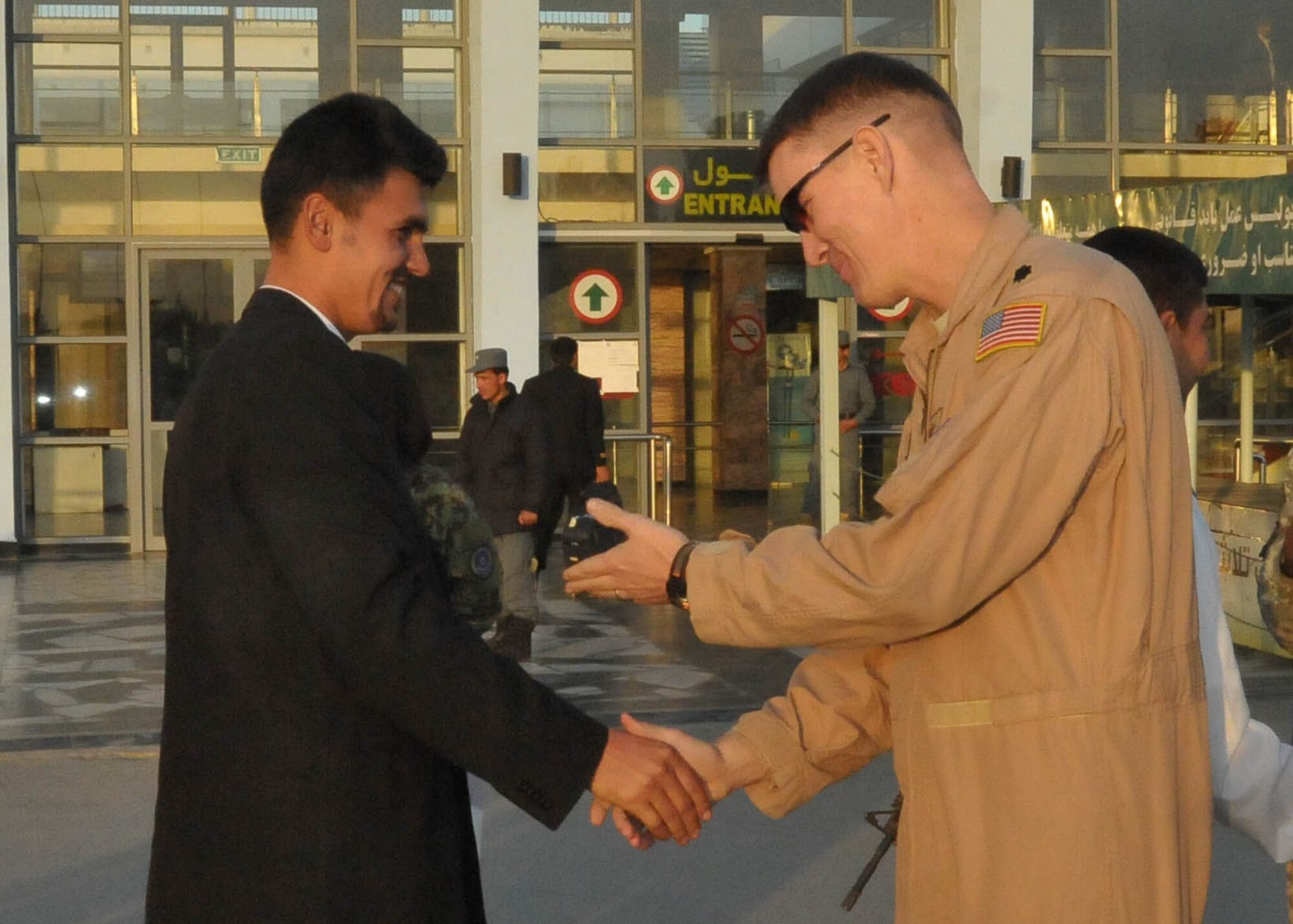 101211-N-6541W-030 KABUL, Afghanistan - A member of the Afghan Air Force who is leaving to go to a partner nation in the middle east for pilot and English training shakes hands with his advisor Lt. Col. John Howard at  Kabul International Airport Dec. 11th.  (U.S. Navy photo by Mass Communication Specialist 3rd Class Jared Walker/ RELEASED).
