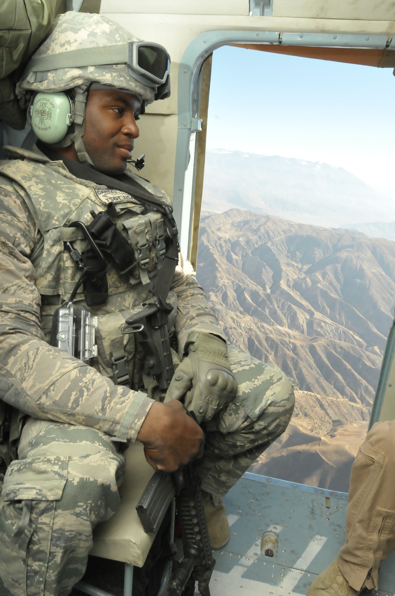 NATO Air Training Command-Afghanistan advisor Tech. Sgt. Ernel Carty sits on an Afghan Air Force Mi-17s to the Badhakshan province where 1,000 dental hygiene kits were given to the village elders to help the community.  (U.S. Navy photo by MC2 Vlad Potapenko/RELEASED).