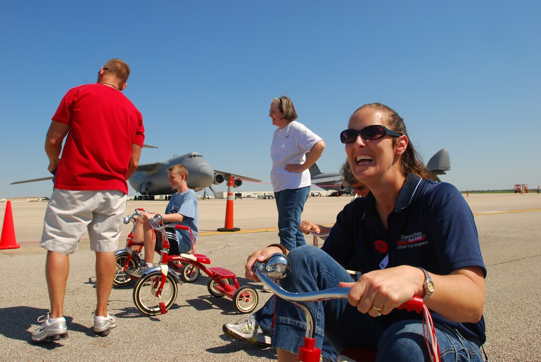 Members of the 433rd Airlift Wing gathered on the Saturday of a combined unit training assembly to celebrate the support of their families during the 2010 Family Day. The event was open to family members of Alamo Wing reservists and featured games, carnival style food and motorcycle and car shows.  Master Sgt. Chelsea Brite, 433rd Civil Engineer Squadron first sergeant, smiles in anticipation of the tricycle race, although she didn't win. (U.S. Air Force photo/Airman 1st Class Brian McGloin)