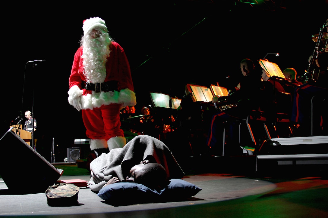 Santa Claus, played by Sgt. Steven Gamet, a musician with Marine Band San Diego, and fellow band member, Lance Cpl. Eric Fisher, act out the narrative for, “Christmas Day, All Secure,” during the 2010 Holiday Concert and Tree Lighting Ceremony Dec. 12.  The concert and tree lighting was held aboard Marine Corps Recruit Depot San Diego.