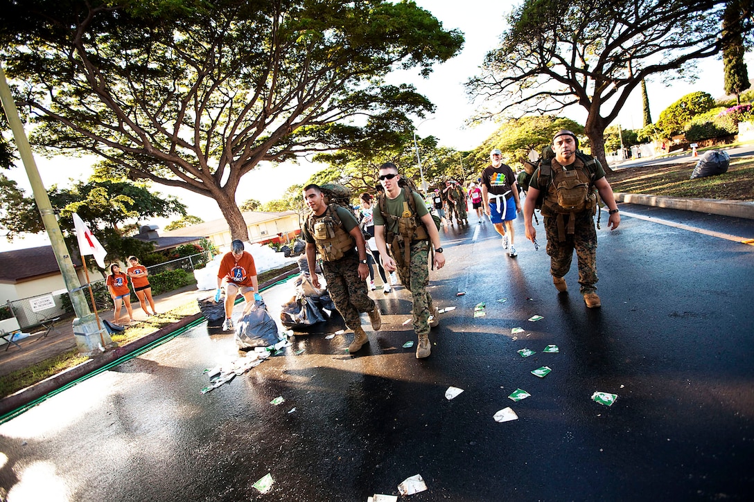 Cpl. Gabriel Rojo and Sgt. Brandon Cox, firefighters with Aircraft Rescue Firefighting, Marine Corps Air Station Kaneohe Bay, Hawaii, and Sgt. Robert Hernandez, a black belt Marine Corps Martial Arts Program instructor with the School of Infantry West — Detachment Hawaii, hike through Honolulu’s outskirts during the 2010 Honolulu Marathon, Dec. 12, 2010. For the second year in a row, the Marines hiked the 26.3-mile marathon with boots, camouflage trousers and 65-pound packs to raise money for wounded Marines and sailors at Wounded Warrior Battalion West — Detachment Hawaii, on Marine Corps Base Hawaii.