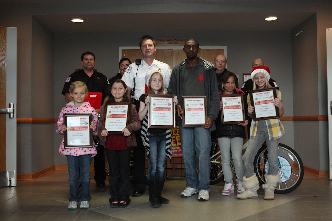 MARINE CORPS BASE CAMP LEJEUNE, N.C. - Glenn Zurek, the assistant chief of Fire Prevention with Fire and Emergency Services Division, Department of Public Safety, Marine Corps Base Camp Lejeune, stands with school children that recently won the Fire Safety Week contests at the Fire and Emergency Services Division main lobby aboard the base, Dec. 14. Prizes included free coupons, bikes and an Xbox.