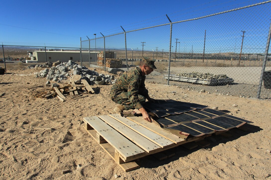 Gunnery Sgt. Andrew Suthers, the operations chief for the Infantry Officer Course out of Quantico, Va., lays out the solar panels that power a Solar Portable Alternative Communications Energy System at the Combat Center Dec. 13, 2010.