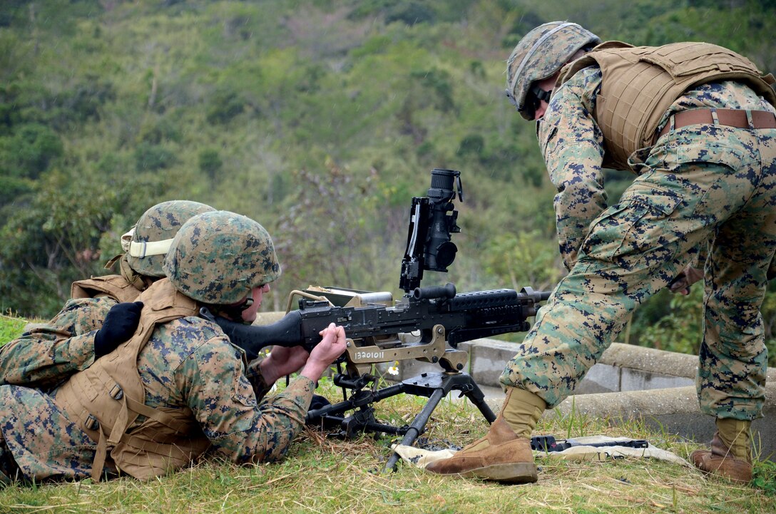 A Marine and his assistant gunner clear an M240G while training on the Machine Gun Day Optic and Ruggedized Miniature Reflex Sight at Range 10 on Camp Schwab recently. ::r::::n::