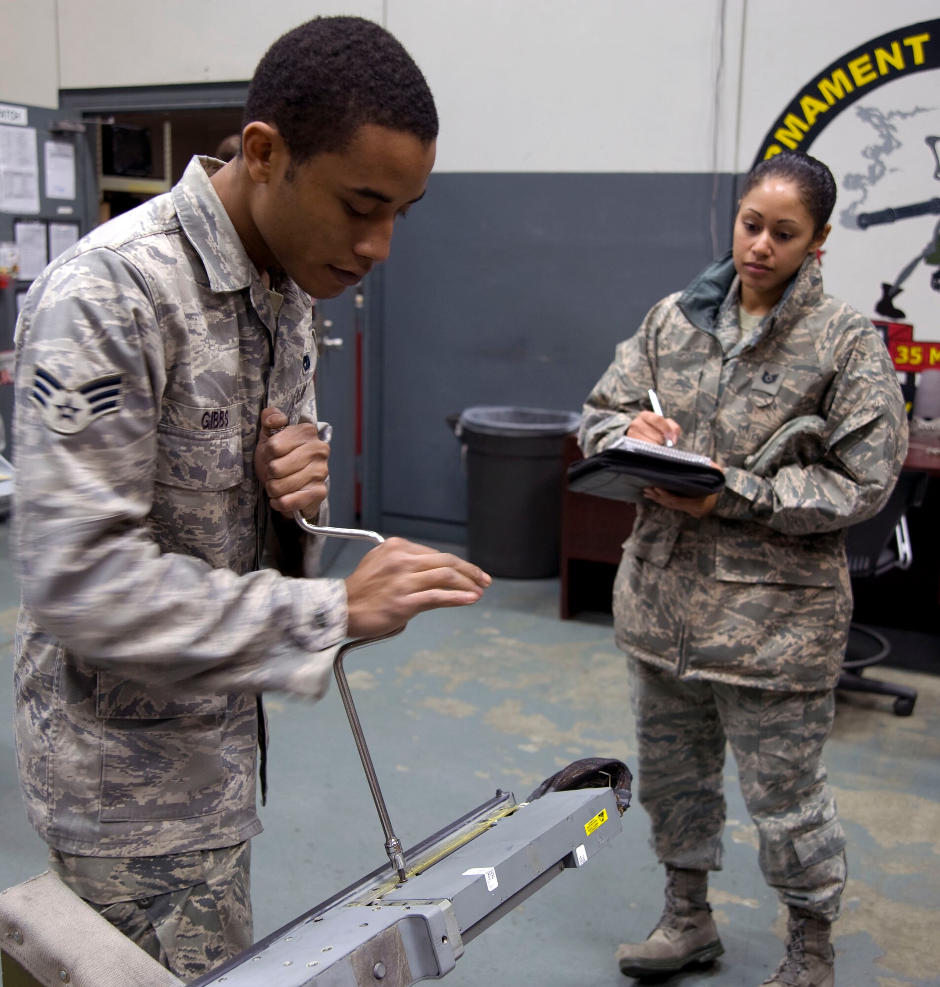 U.S. Air Force Staff Sgt. Monique Duverglaus, right, 35th Maintenance Group, evaluates Senior Airman Craig Gibbs, 35th Maintenance Squadron, removing an access panel missile launcher at Misawa Air Base, Japan, Dec. 10, 2010. QA establishes and implements the maintenance standardization and evaluation program of acceptable quality level making the wing mission a success. (U.S. Air Force photo by Tech. Sgt. Russell McBride/Released)