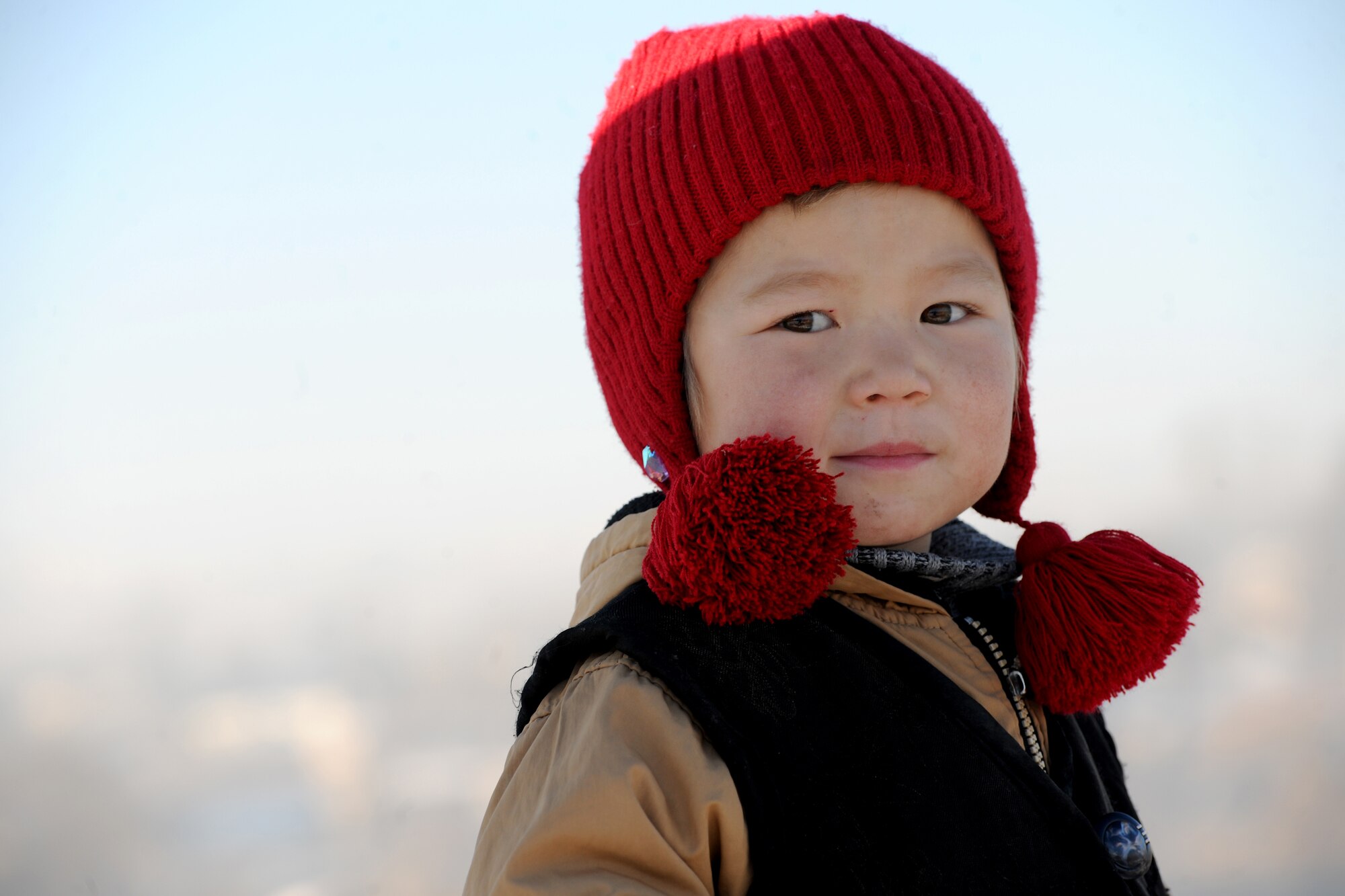 BISHKEK, Kyrgyzstan -  A Kyrgyz child watches on as Airmen from the Transit Center at Manas teamed up with the local government, community residents and Koi-Tosh Non-Commissioned Officer Academy military members for a community clean up. More than 100, 30-gallon bags were filled with trash. The First Four, a professional organization made up of Airmen in the first four junior ranks, organized the event for the Enesay community, just outside Bishkek.  (U.S. Air Force photo/Staff Sgt. Nathan Bevier)