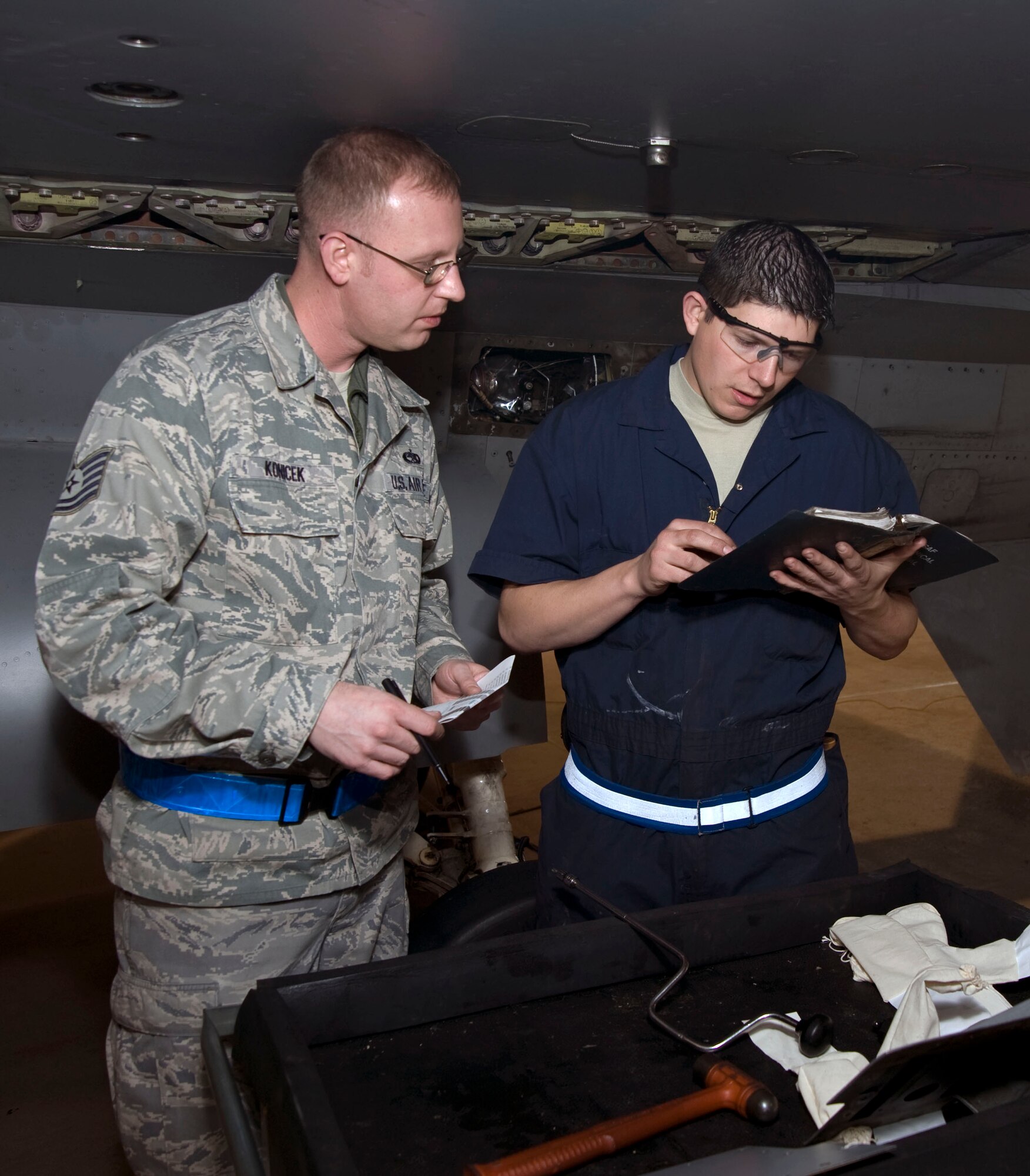 U.S. Air Force Tech. Sgt.  Kristopher Konicek, left, 35th Maintenance Group, quality assurance inspector, performs an evaluation inspection on Staff Sgt. Travis Scates , 35th Maintenance Squadron while working  on an F-16 Fighting Falcon at Misawa Air Base, Japan, Dec. 10, 2010. Members of the aircraft maintenance world are evaluated every 18 months. (U.S. Air Force photo by Tech. Sgt. Russell McBride/Released)
