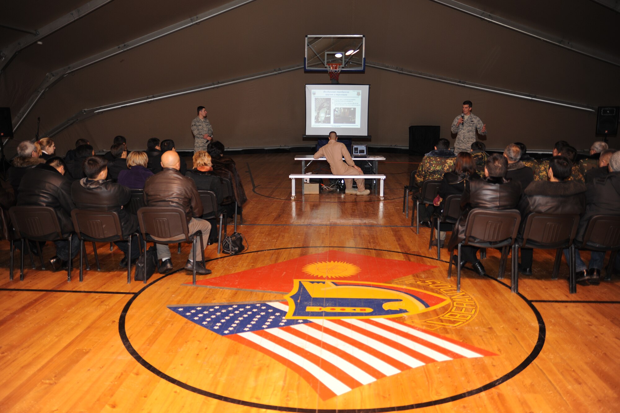 TRANSIT CENTER AT MANAS, Kyrgyzstan - Col. Dwight Sones, 376th Air Expeditionary Wing commander, shares to four missions of the Transit Center with the help of linguist Senior Airman Ilya Volovik. The Kyrgyz military graduates of the George C. Marshall Center, Germany, visited  Dec. 11. About 50 Kyrgyz alumni were given a tour of the installation and climbed aboard a C-17 Globemaster III. (U.S. Air Force photo/Staff Sgt. Nathan Bevier)