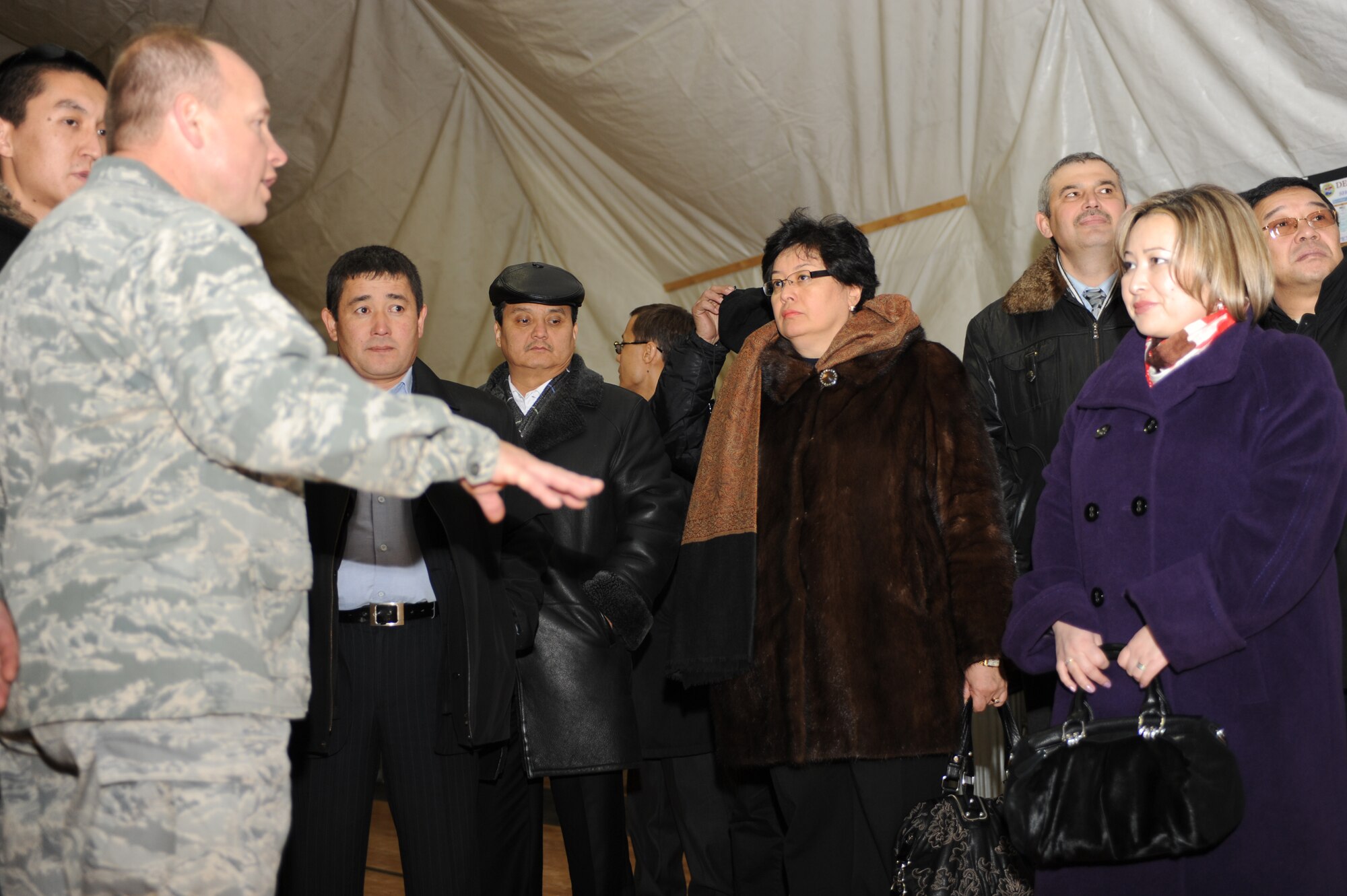 TRANSIT CENTER AT MANAS, Kyrgyzstan - Col. Brian Brandner, 376th Air Expeditionary Wing vice commander, provides a tour of the fitness center to Kyrgyz military graduates of the George C. Marshall Center, Germany, during an alumni event hosted by the U.S. Embassy Dec. 11. About 50 Kyrgyz members were given a Transit Center mission briefing, toured the installation and climbed aboard a C-17 Globemaster III.  (U.S. Air Force photo/Staff Sgt. Michael Schocker)
