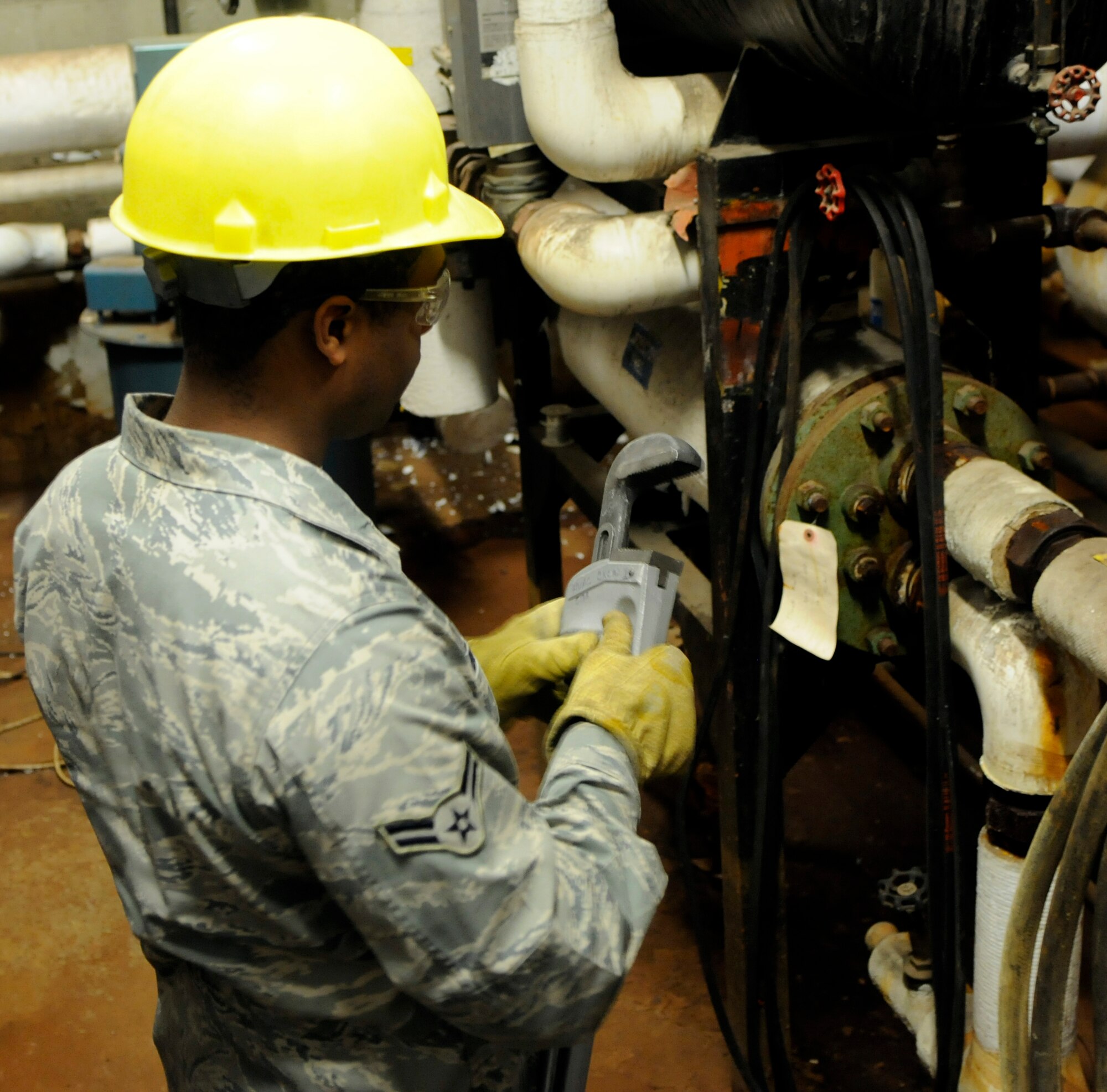 Airman 1st Class Chad Burton readies a large wrench before inspecting various pipes within a boiler room Nov. 30, 2010, Eielson Air Force Base, Alaska. The 354th Civil Engineering Squadron heating ventilation air conditioning shop performs inspections and maintains everything from residential air conditioning systems to boilers at non-residential buildings at Eielson. Airman Burton is assigned to the 354th CES HVAC shop. (U.S. Air Force photo by/Airman 1st Class Yash Rojas)