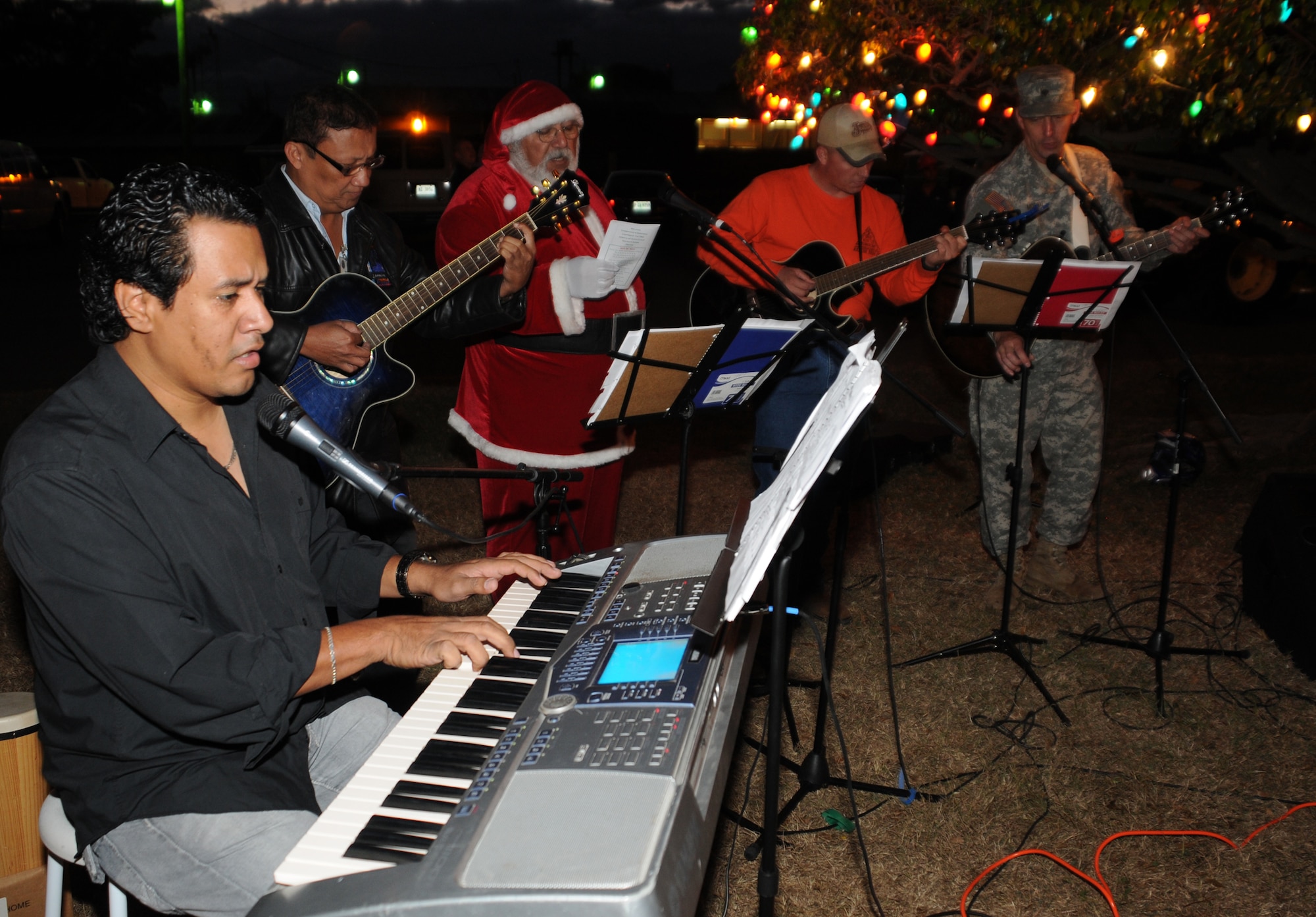 SOTO CANO AIR BASE, Honduras --  The Friendship Chapel Worship Band plays a rendition of "Feliz Navidad" during the Christmas tree lighting ceremony here Dec. 10. The event, which was hosted by the base Chapel, also featured holiday fare including hot chocolate and egg nog. (U.S. Air Force photo/Tech. Sgt. Benjamin Rojek)