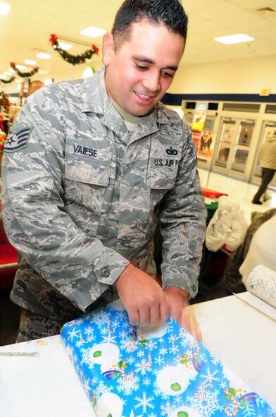Staff Sgt. Mario Vaiese, 2nd Security Forces Squadron, wraps a gift outside the Base Exchange located on Barksdale Air Force Base, La., Dec. 13. Volunteers from 2 SFS donated their time to raise money for their holiday party. (U.S. Air Force photo by Senior Airman Joanna M. Kresge)