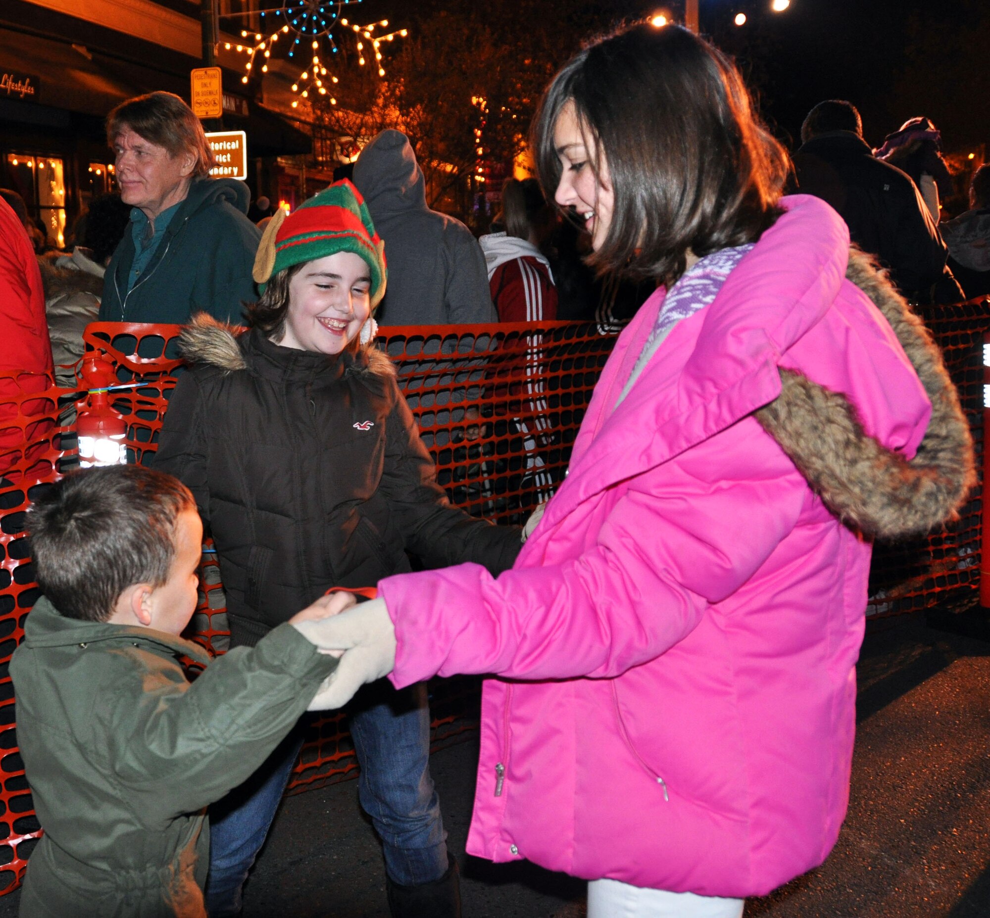 TRAVIS AIR FORCE BASE, Calif. -- All was merry on Main Street in downtown Vacaville, Nov. 30, in preparation for the holiday season. Pictured, from the left, Jack Flournoy, Elyse Gottschall, and Emily Flournoy, in pink, dance together after the switch is flipped to light up the town's giant holiday tree. Flipping the switch together were Vacaville Mayor, Len Augustine, 60th Air Mobility Wing Commander, Col. James Vechery, 615th Contingency Response Wing Commander, Col. Gary Gottschall, 15th Expeditionary Mobility Task Force Vice Commander, Col. John Lipinski, 349th AMW Commander, Col. Jay Flournoy, and A1C Michael Battles, 60th AMW public affairs. (U.S. Air Force photo/courtesy photo)