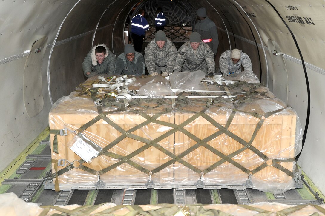 Airmen from the 509th Logistics Readiness Squadron push pallets of Los Angeles-class submarine batteries to the back of a DC-8 cargo jet, Dec. 4, 2010, at Whiteman Air Force Base, Mo. (U.S. Air Force photo/Senior Airman Carlin Leslie)
