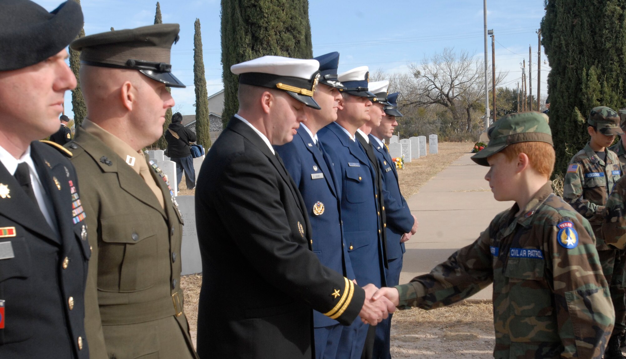 SAN ANGELO, Texas – A member of the Civil Air Patrol shakes hands with Navy Lt. Lonnie Griffith, U.S. Navy Center for the Information Dominance Detachment Officer in Charge, at the conclusion of the National Wreaths Across America Ceremony Dec. 11 in San Angelo.  Wreaths Across America was formed in 2007 to promote veterans remembrance.  Wreaths are placed on veterans graves during the holiday season.  (U.S. Air Force photo/Kent Cummins)