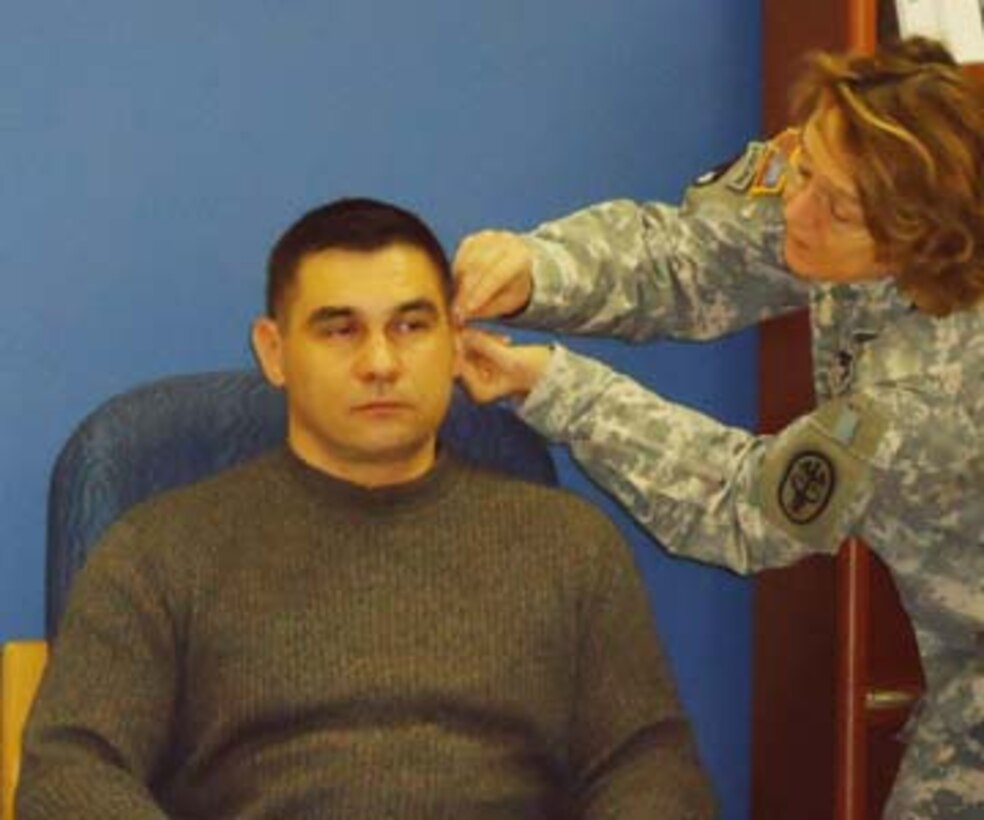 Army Capt. Taras Chuhaj receives acupuncture for pain from Colonel Patricia Lillis-Hearne during a workshop at the Air Force Acupuncture Center at Joint Base Andrews in Maryland, Dec. 9, 2010. The purpose of the class was to teach battlefield acupuncture to military physicians from Walter Reed Army Medical Center.