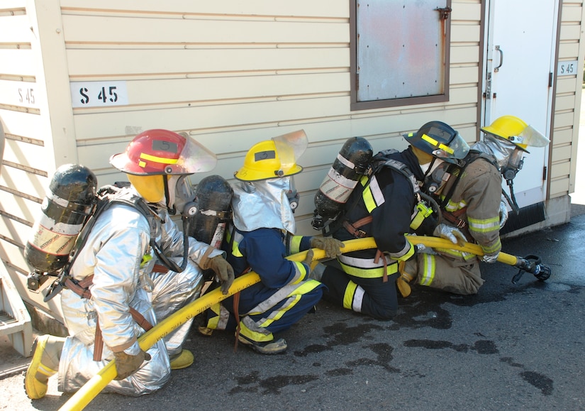 SOTO CANO AIR BASE, Honduras - Firefighters from the U.S., Honduras and El Salvador prepare to breach the structural fire training building here, 8 Dec., during the landmark firefighting training exercise known as Central America Sharing Operational Knowledge and Experiences. CENTAM SMOKE is a week-long, quarterly event designed to enhance firefighting capabilities throughout Central America. (U.S. Air Force photo by Capt. John T. Stamm)