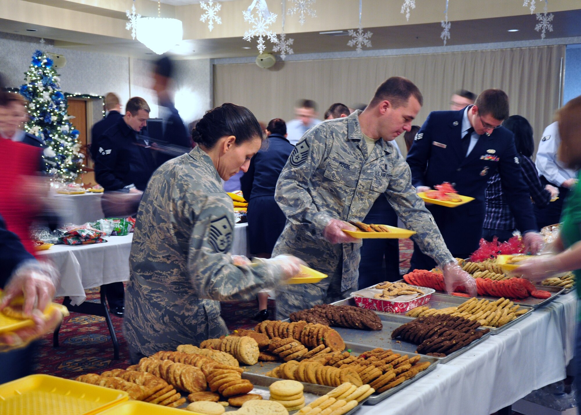 Master Sgt. Jeanine Steele, 90th Security Support Squadron first sergeant, and Master Sgt. David Moore, 90th Security Forces Squadron first sergeant, put together cookie trays Dec. 6 in the Trail’s End Club for Airmen living in the dorms here. (U.S. Air Force photo by 2nd Lt. Stacey Fenton)