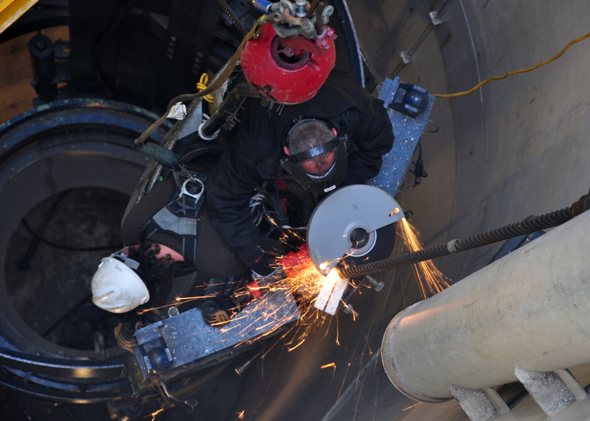 A maintenance crew member from Hill Air Force Base, Utah cuts a support cable for the missile support system on Dec. 7 at Uniform-1. (U.S. Air Force photo by Staff Sgt. Chad Thompson)