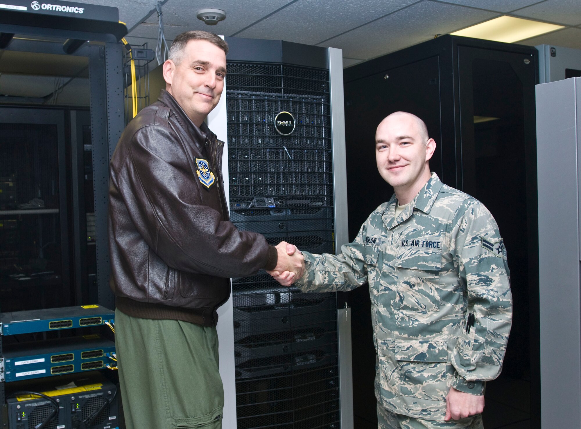 Col. Mike Minihan (left), 19th Airlift Wing commander, presents his commander’s coin Dec. 10, 2010, to Airman 1st Class Jay Winslow, a 19th Communications Squadron network administrator, for his selection as the Combat Airlifter of the Week at Little Rock Air Force Base, Ark. Airman Winslow led the recent 78-server migration, enhancing network security for the 19th Medical Group and base flying units. (U.S. Air Force photo by Staff Sgt. Nestor Cruz)