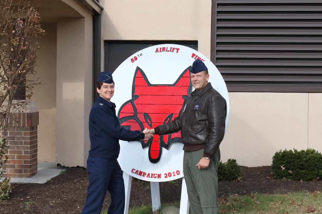 Col. Jacqueline Van Ovost, 89th Airlift Wing commander, thanks Senior Master Sgt. Chuck Gardner, 89th Operations Group Computer Systems Operator functional manager, for his efforts in helping the 89 AW become the first large organization Air Force National Capital Region to achieve their Combined Federal Campaign goal. As of Dec. 8, the 89 AW had collected more than $94,000 or 106 percent of their goal, exceeding their previous year's goal by three percent. (U.S. Air Force photo/ Maj. Gabe Behr) 