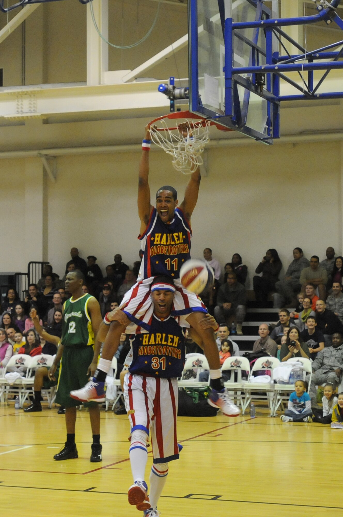 Globetrotter guard "Cheese" Chisholm receives a lift from forward "Hammer" Harrison with dunking the ball at the Dragon Fitness Center during an exhibition game against the Washington Generals Dec. 2. The Globetrotters also performed different skits and tricks throughout the course of their game.(U.S. Air Force photo/Airman 1st Class LaVel Sterling)