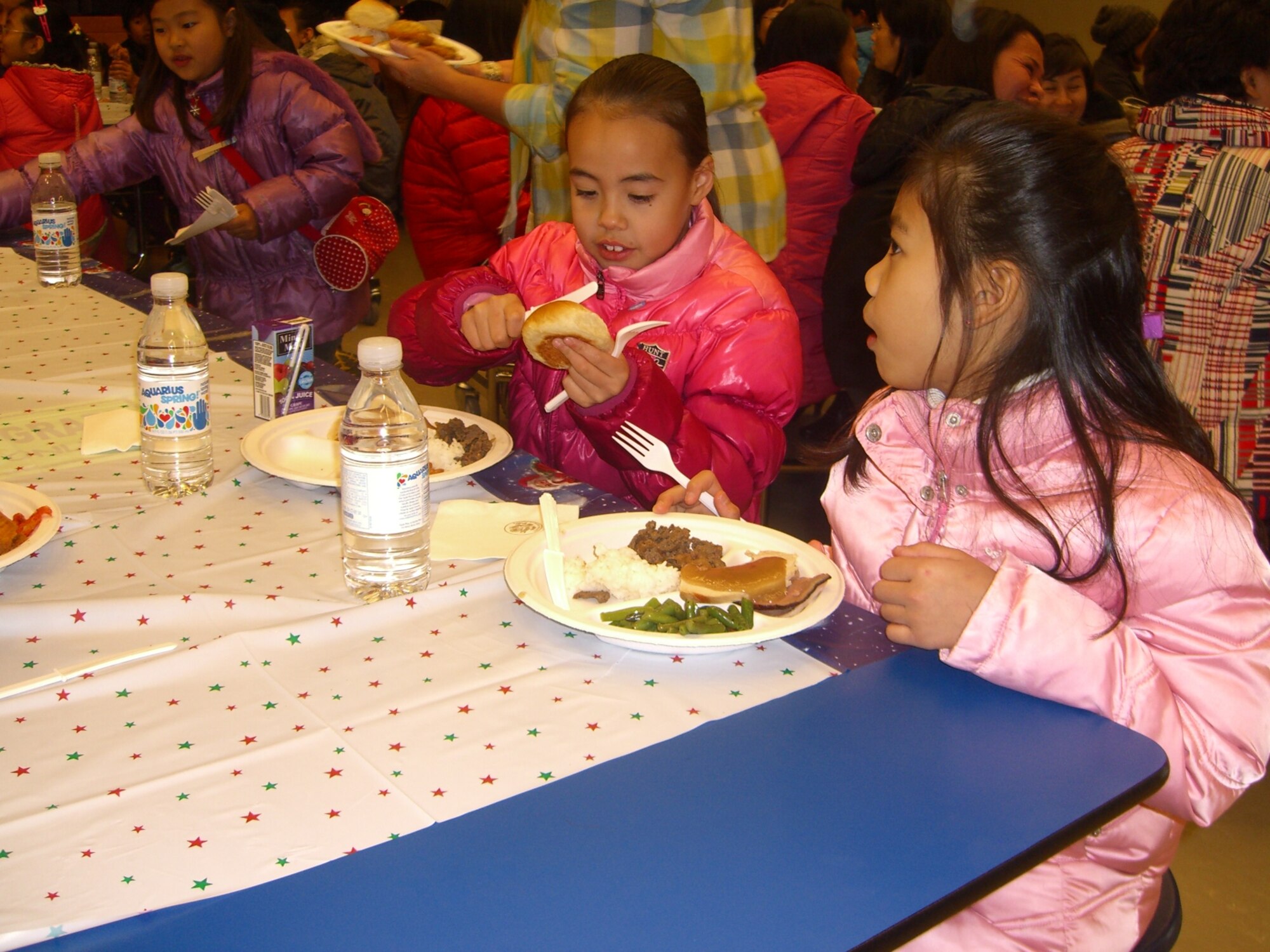 Children enjoy a holiday meal during the Pearl S. Buck Christmas Party at Osan Dec. 4. (Courtesy photo)