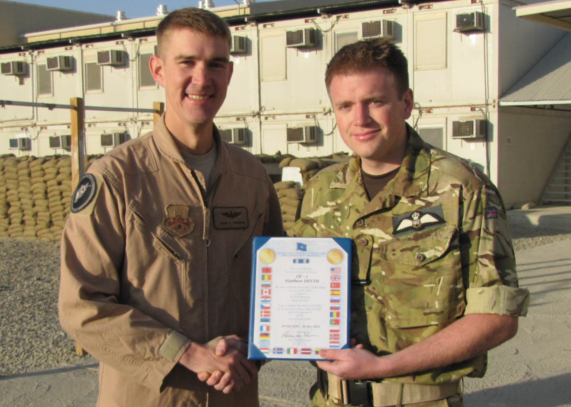 KABUL, Afghanistan - Members of NATO Air Training Command-Afghanistan celebrated the accomplishments of Royal Air Force Flying Officers Matthew Smyth and Lee Southward and the impact they had on the Thunder Lab at Kabul, Afghanistan during their two months in country, Dec.13. Both officers were presented with the NATO medal for their actions. (U.S. Navy Photo by MC3 Jared E. Walker/RELEASED).