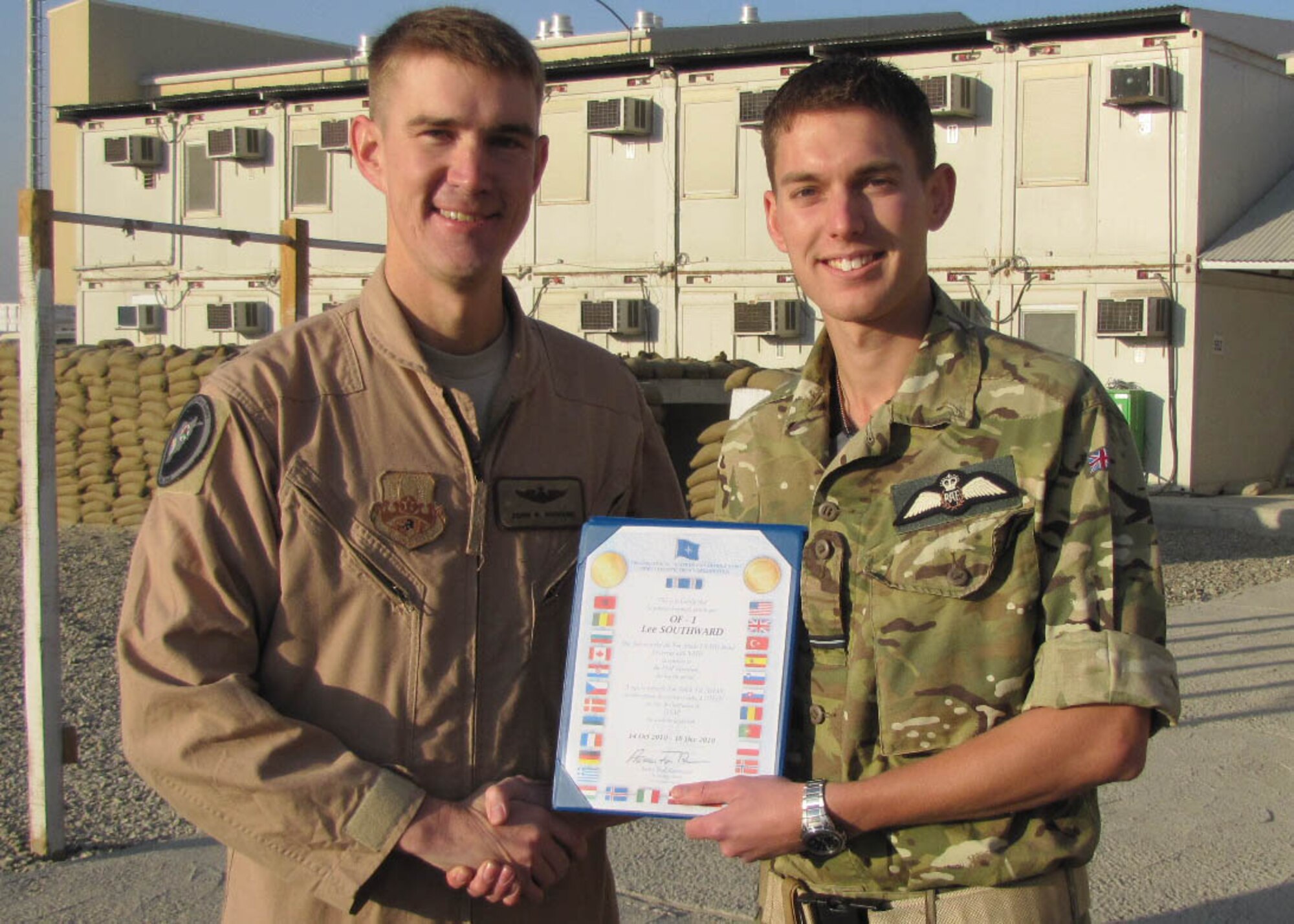 KABUL, Afghanistan - Members of NATO Air Training Command-Afghanistan celebrated the accomplishments of Royal Air Force Flying Officers Matthew Smyth and Lee Southward and the impact they had on the Thunder Lab at Kabul, Afghanistan during their two months in country, Dec.13. Both officers were presented with the NATO medal for their actions. (U.S. Navy Photo by MC3 Jared E. Walker/RELEASED).