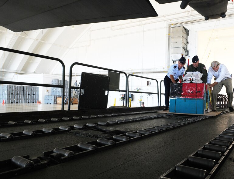 Col. Tod Fingal, 36th Wing vice commander, Col. Paul ?Otto? Feather, 374th Airlift Wing commander, Yokota Air Base, Japan and Mr. Bruce Best, University Of Guam researcher, push the first box into a C-130 Hercules during the Operation Christmas Drop Push Ceremony at Andersen Air Force Base, Guam, Dec. 13., marking the beginning of Operation Christmas Drop 2010. Through the cooperation of local and military communities in the Asia-Pacific region, Operation Christmas Drop has delivered more than 800,000 pounds of food, supplies, tools, and toys to thousands of residents throughout Micronesia. (U.S. Air Force photo/ Senior Airman Nichelle Anderson) 