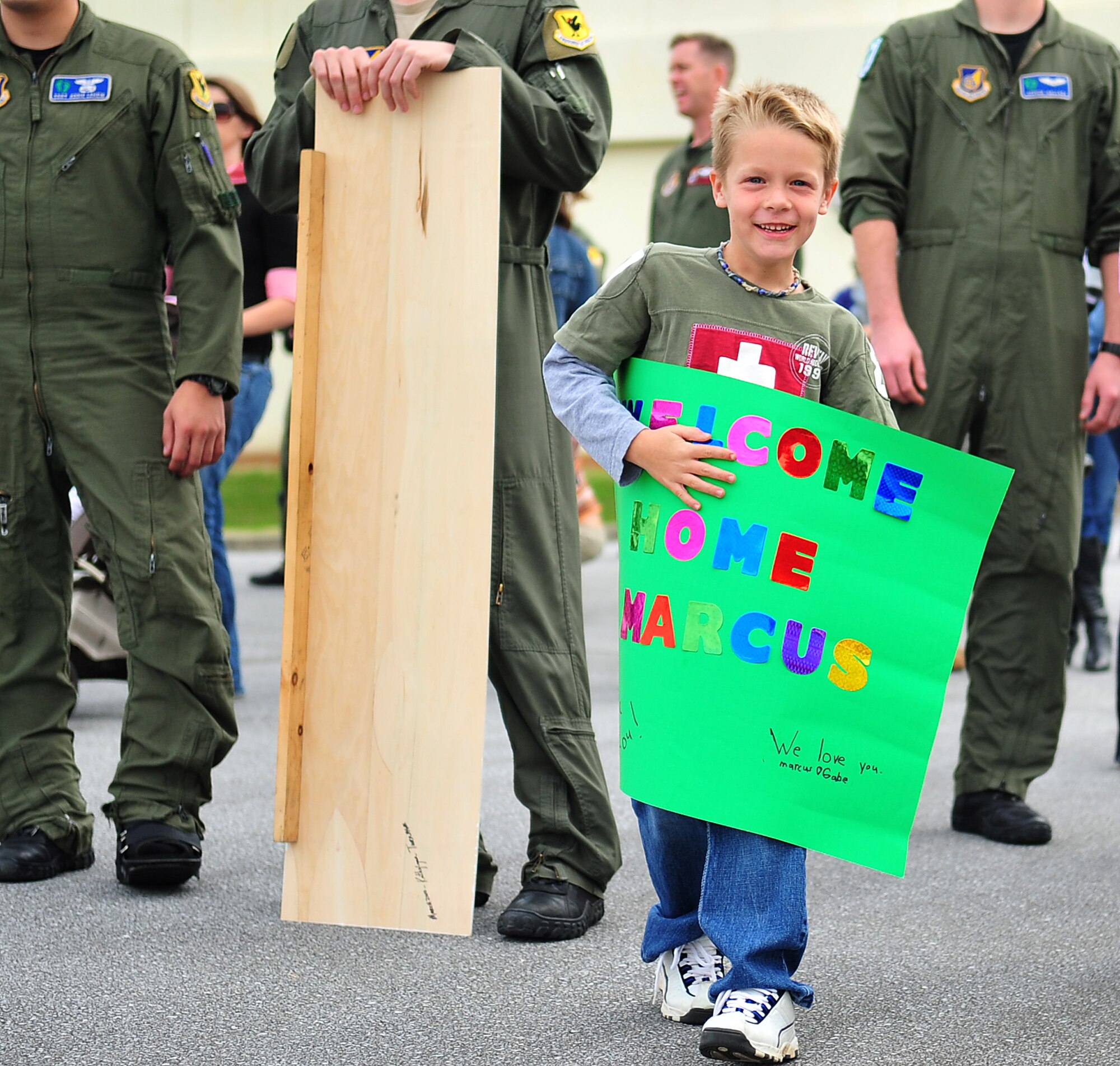 Gabe Baker, 7, holds a sign welcoming home his father, Technical Sgt. Marcus Baker, a member of the 33rd RQS, from a deployment in support of Operation Enduring Freedom, Dec. 9. Seventy-five members of the 33rd RQS and 33rd Helicopter Maintenance Unit returned to Kadena Dec. 9 and 10 from a deployment to the 83rd Expeditionary Rescue Squadron at Bagram Air Base, Afghanistan. (U.S. Air Force photo/ Staff Sgt. Alesia D. Goosic)