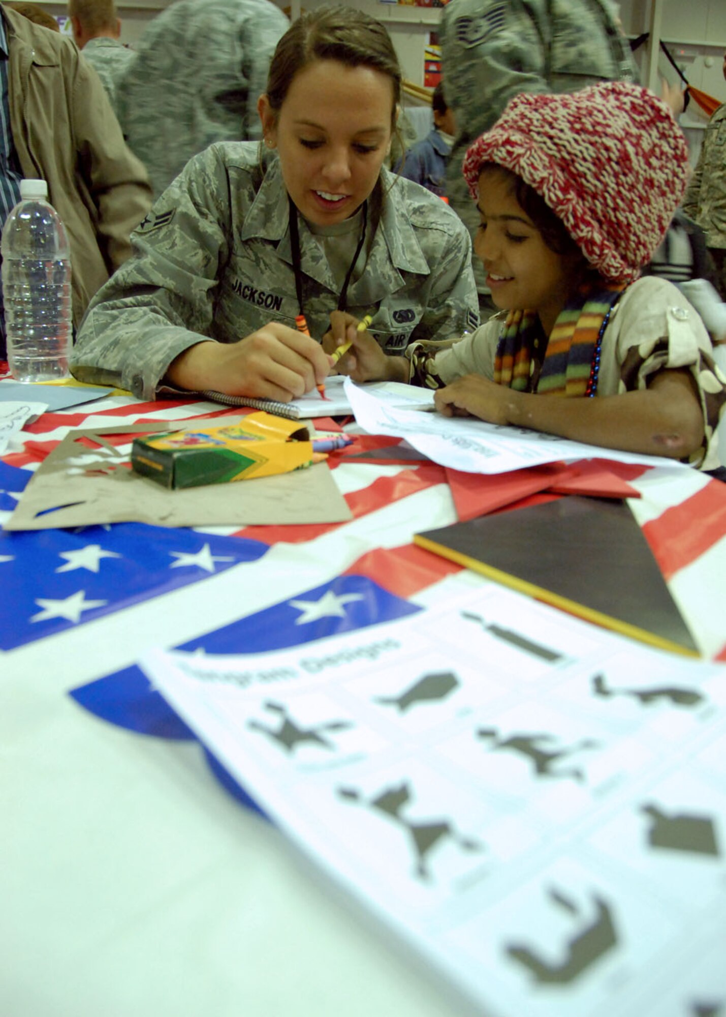 JOINT BASE BALAD, Iraq – Airman 1st Class Kelsey Jackson, 777th Expeditionary Aircraft Maintenance Unit day shift supply member, watches the child she mentored write `out “I love you” in Arabic during Iraqi Kids Day Dec. 11, 2010. More than 70 local Iraqi youths participated in the event which is designed to build positive relations with the nearby community. Airman Jackson is deployed from Little Rock Air Force Base, Ark., and is a native of Manhattan, Kan. (U.S. Air Force photo/ Senior Airman Tong Duong)