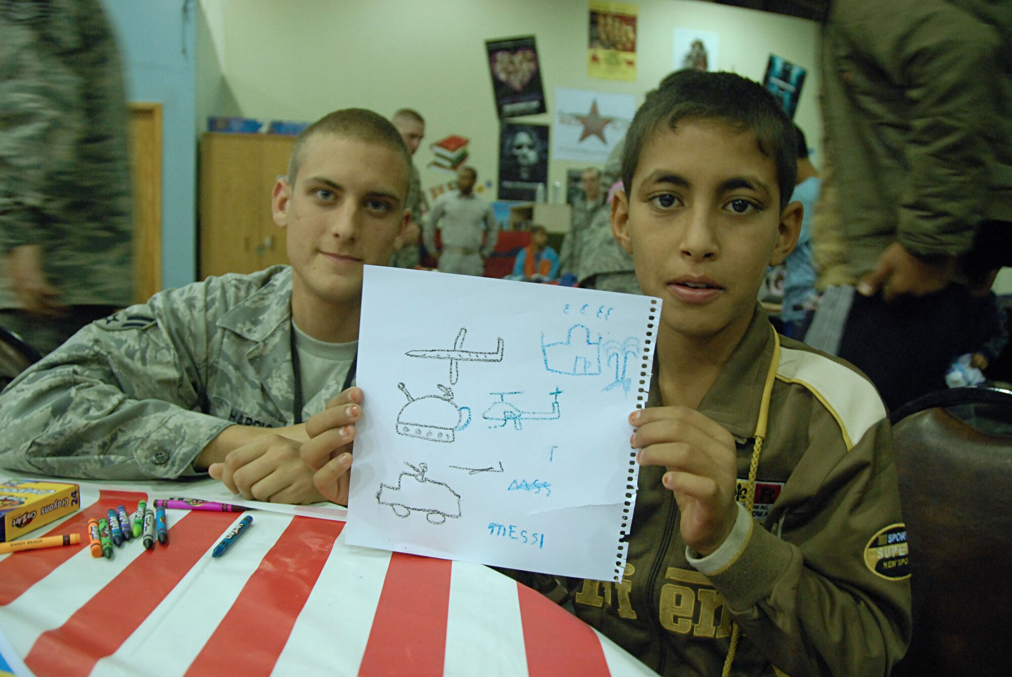 JOINT BASE BALAD, Iraq – Airman 1st Class Jordan Harris, 332nd Expeditionary Aircraft Maintenance Squadron, poses with the child he mentored during Iraqi Kids Day Dec. 11, 2010. The IKD event is hosted here quarterly to build positive relations with the local community. Airman Harris is deployed from Misawa Air Base, Japan, and is a native of Pensacola, Fla. (U.S. Air Force photo/ Senior Airman Tong Duong)