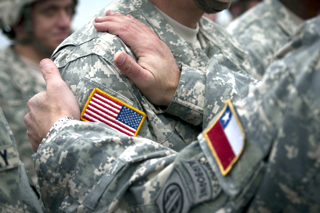 A Chilean jumpmaster pins his Army's jump wings on a U.S. Army paratrooper at Fort Bragg, N.C., Dec. 11, 2010, as part of Operation Toy Drop.