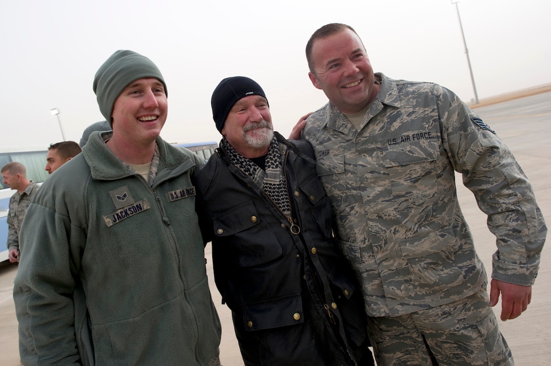 Comedian Robin WIlliams poses for photos with U.S. Air Force airman at al-Asad Airbase in Iraq on Dec. 13, 2010. Williams is one of several entertainers accompanying U.S. Adm. Mike Mullen, chairman of the Joint Chiefs of Staff, during a tour in the Central Command area of responsibility.