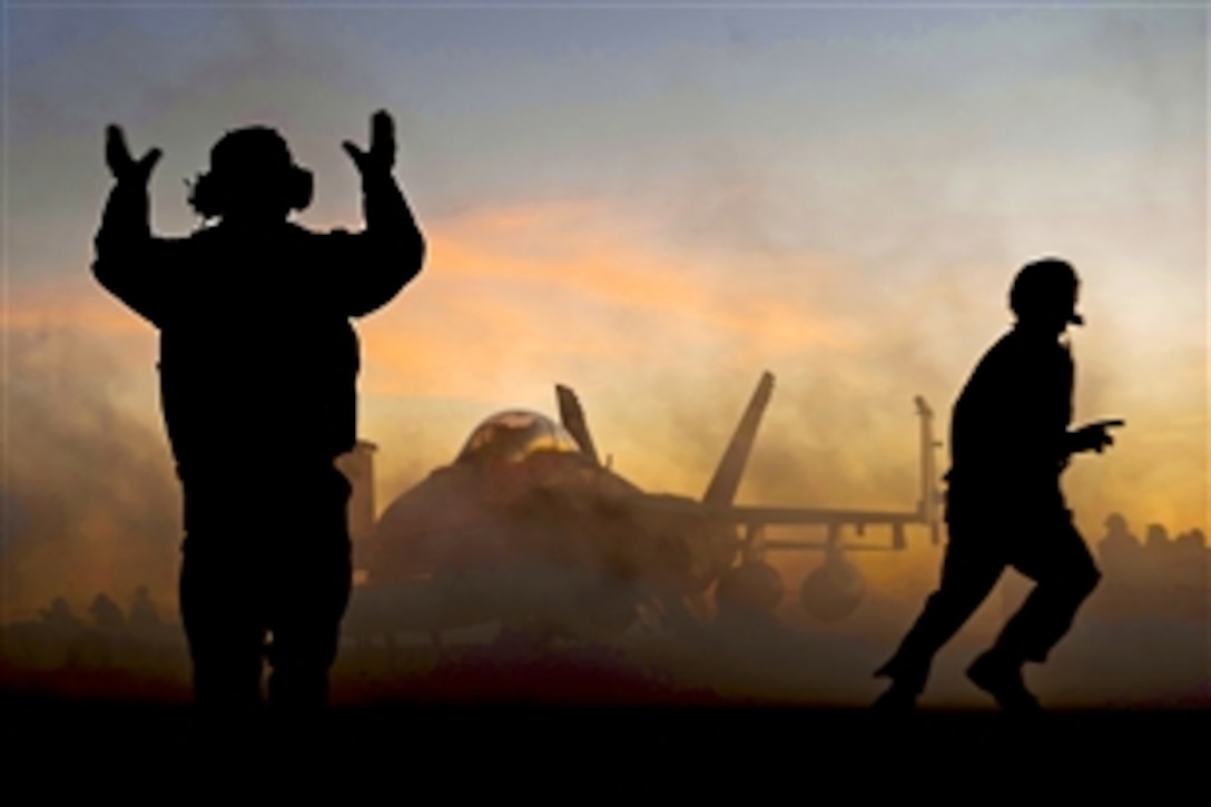 An aircraft director guides an F/A-18F Super Hornet after it made an arrested landing on the flight deck of the aircraft carrier USS Carl Vinson in the Pacific Ocean, Dec. 11, 2010. The Carl Vinson and Carrier Air Wing 17 are on a three-week training exercise before a deployment to the western Pacific Ocean. The Hornet is a part of Strike Fighter Squadron 22. 