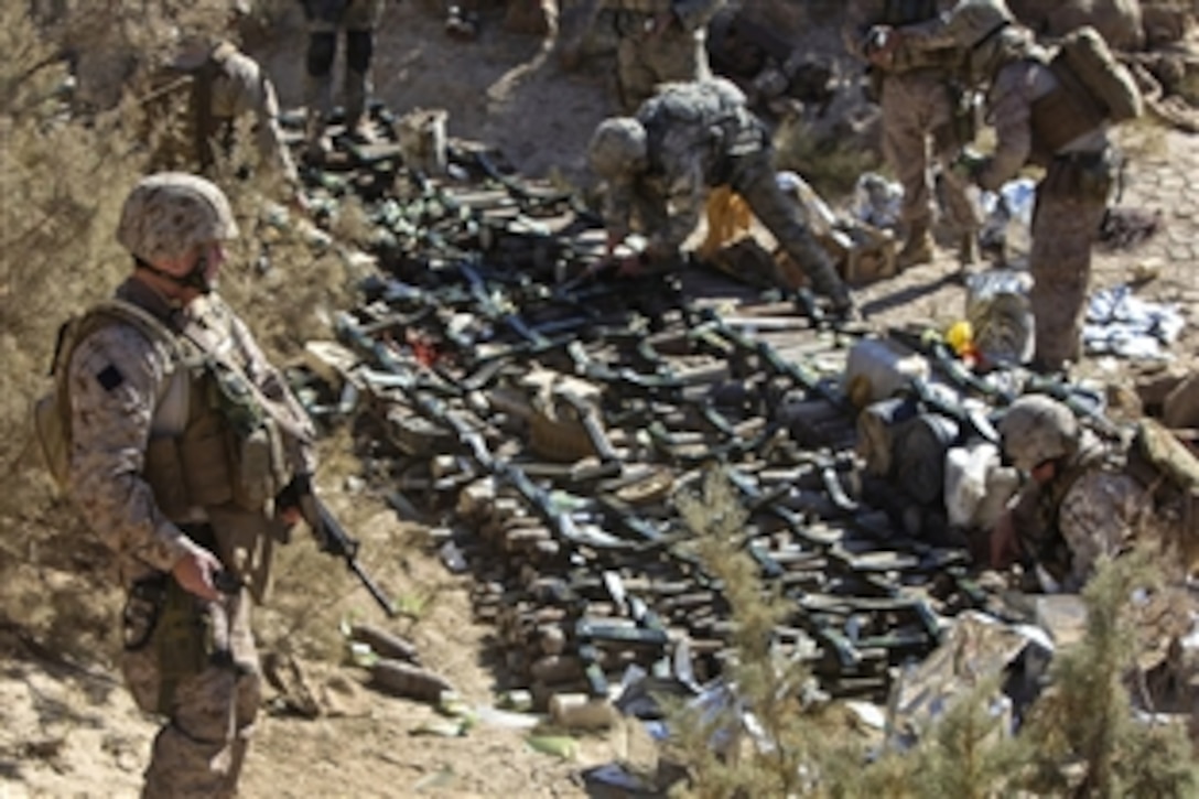 U.S. Marine Corps Lt. Col. Michael Geffroy observes as explosive ordnance disposal team members gently place unexploded ordnance in line to be destroyed at Cigini, Afghanistan, Dec. 10, 2010. Geffroy is the Regional Command Southwest's stability operations governance officer in-charge.