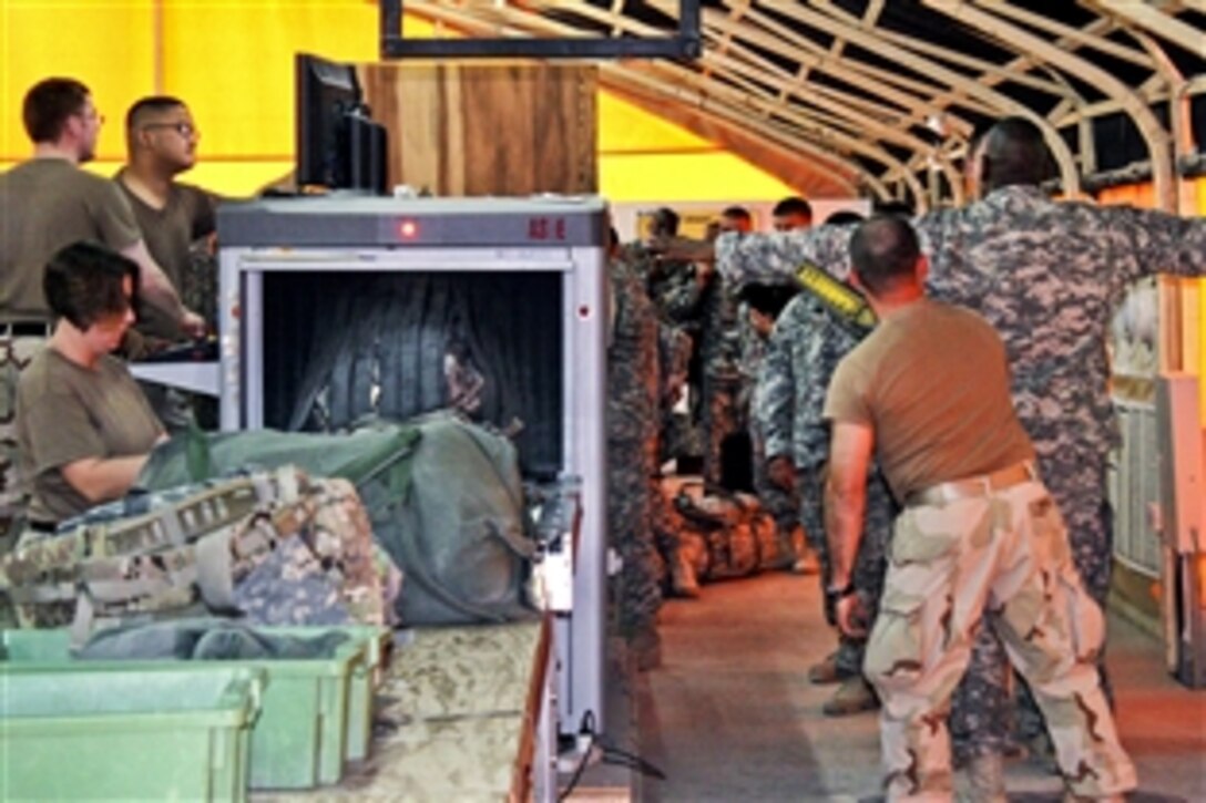 U.S. Navy sailors with Navy Customs screen luggage and travelers at the Army Life Support Area in Kuwait, Dec. 12, 2010. As of November, more than one million military members and civillians have passed through the area on their way home for rest and recuperation travel. 