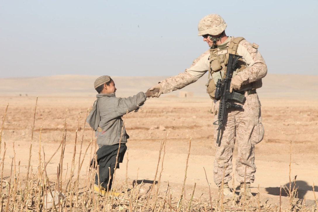 Staff Sgt. Cary Anderson, a team leader with Lima Company, 3rd Battalion, 25th Marine Regiment, greets an Afghan child in Habibabad during a joint patrol, Dec. 13. Marines and Danish soldiers, alongside their Afghan National Army counterparts met with locals during a joint patrol to establish relationships in the area.