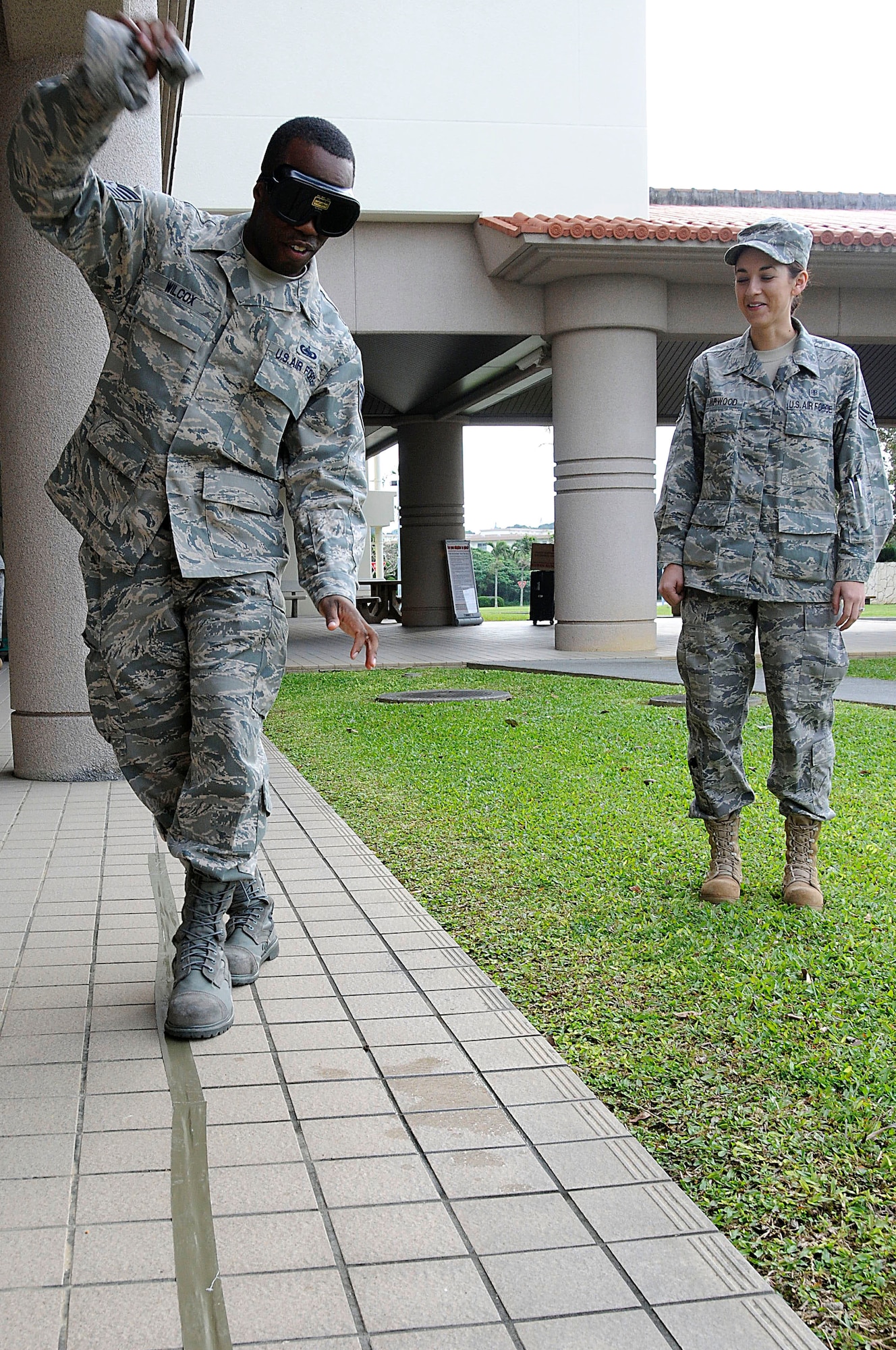 Tech. Sgt. Derrick Wilcox, 18th Logistics Readiness Squadron maintenance supply liaison, tries to walk in a straight line while wearing .25 blood alcohol content level drunk goggles during an outreach event for National Drunk and Drugged Driving Prevention Month at Kadena Air Base, Dec. 15. During the event, 18th Wing personnel wore the goggles and tried riding a bike around cones, walking in a straight line and shooting a basketball into a hoop, all to learn how difficult it is to perform typically simple tasks while under the influence. (U.S. Air Force photo/Staff Sgt. Darnell T. Cannady)